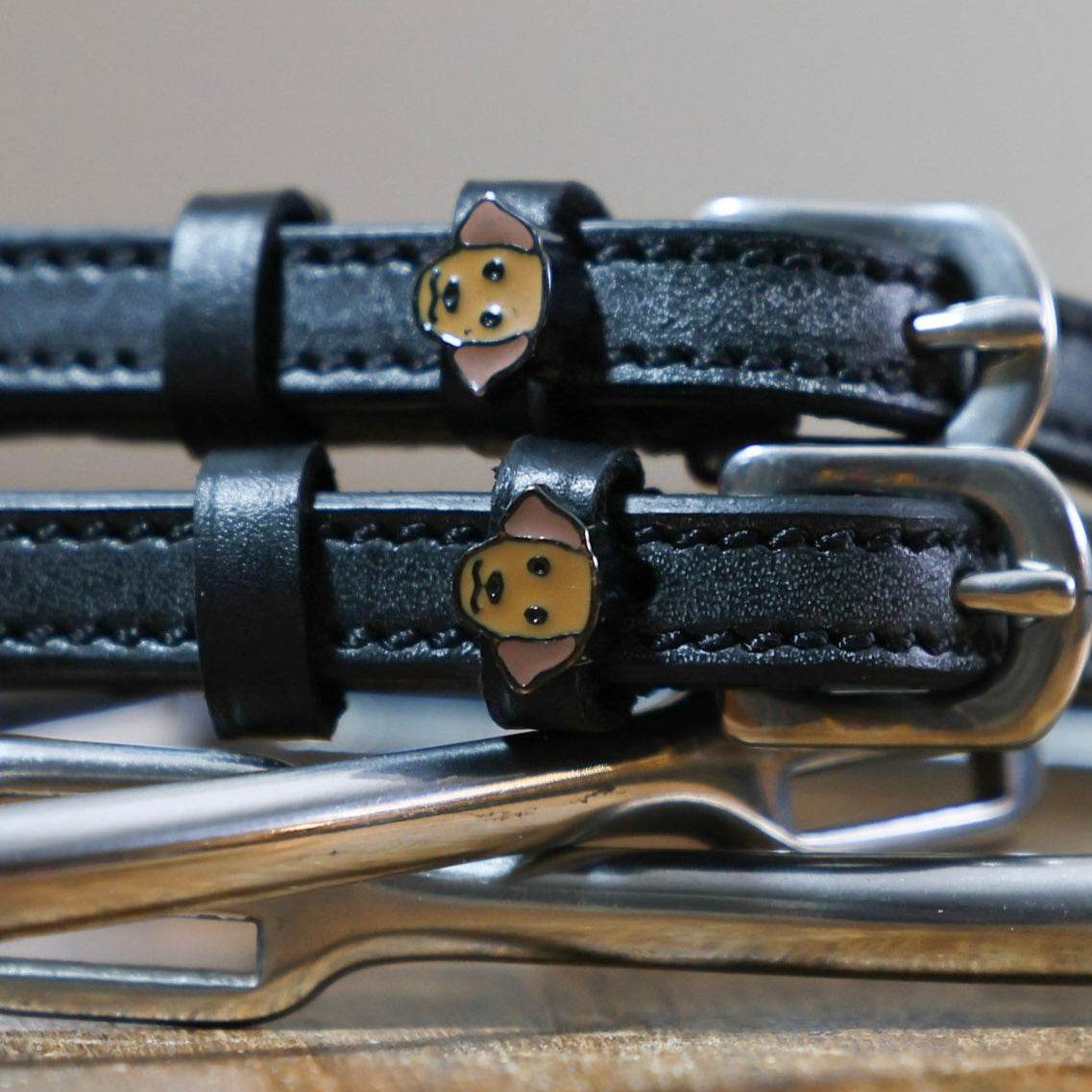 Black leather dog-themed spur straps with stainless steel buckles and custom charm