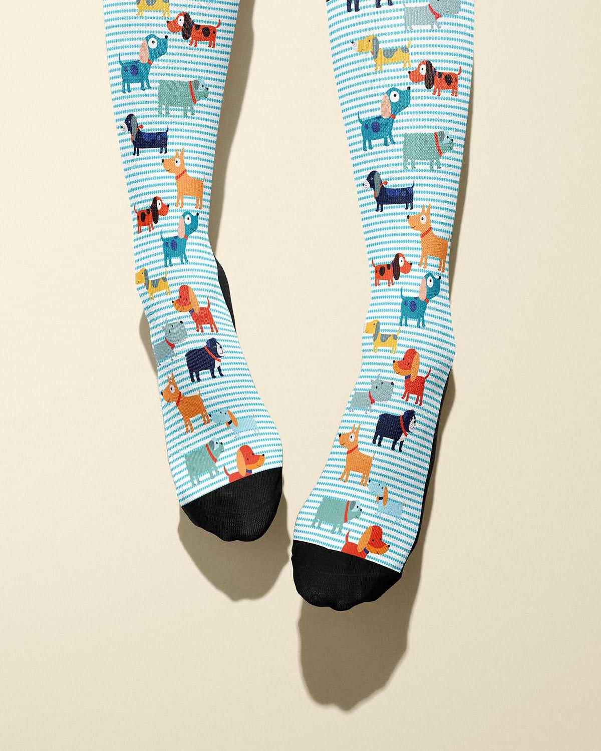 Limited edition Dog Park boot socks featuring playful vector dogs and black cuffs, made in the USA.