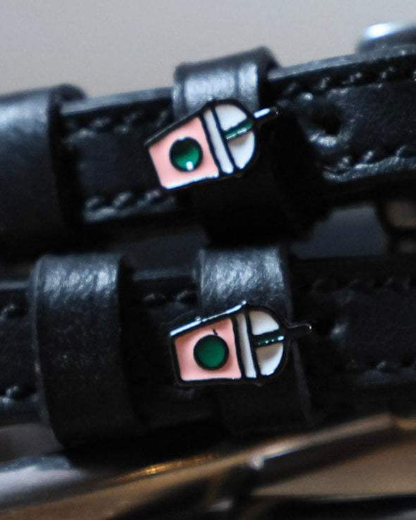 Black leather Frappe Spur Straps with stainless steel buckle and custom charm for durable, stylish riding gear