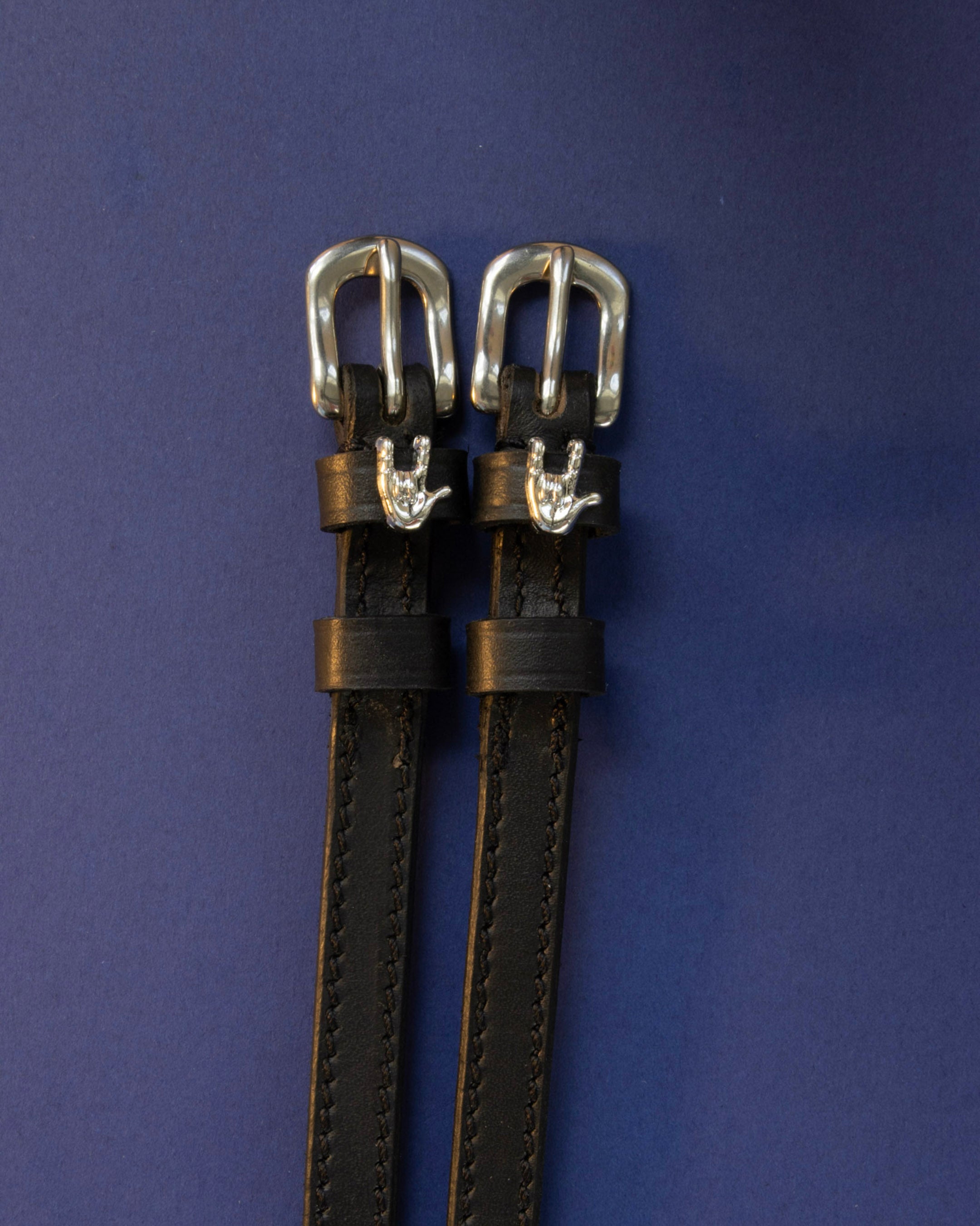 Rock On ManeJane spur straps with the signature Rock On charm, shown on a navy background