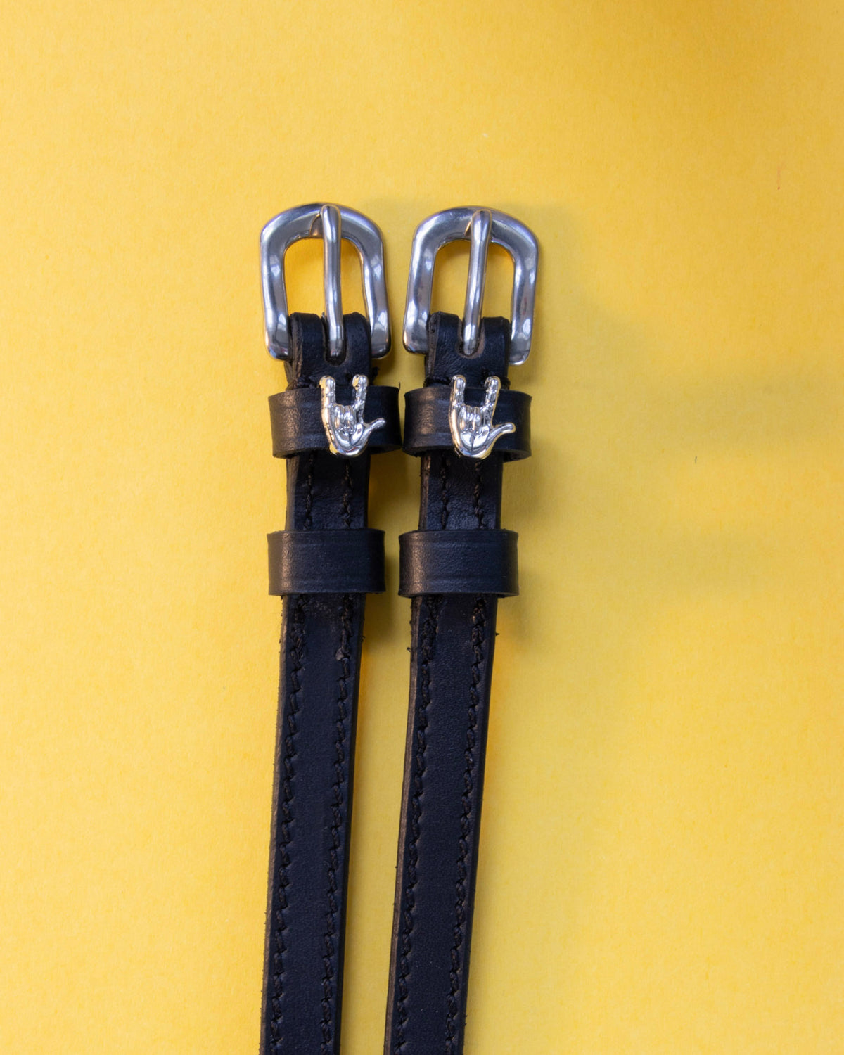 Rock On ManeJane spur straps with the signature Rock On charm, shown on a yellow background