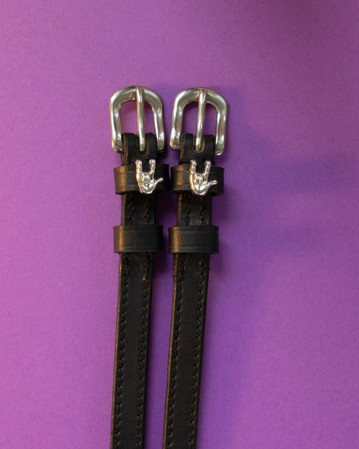 Rock On ManeJane spur straps with the signature Rock On charm, shown on a purple background