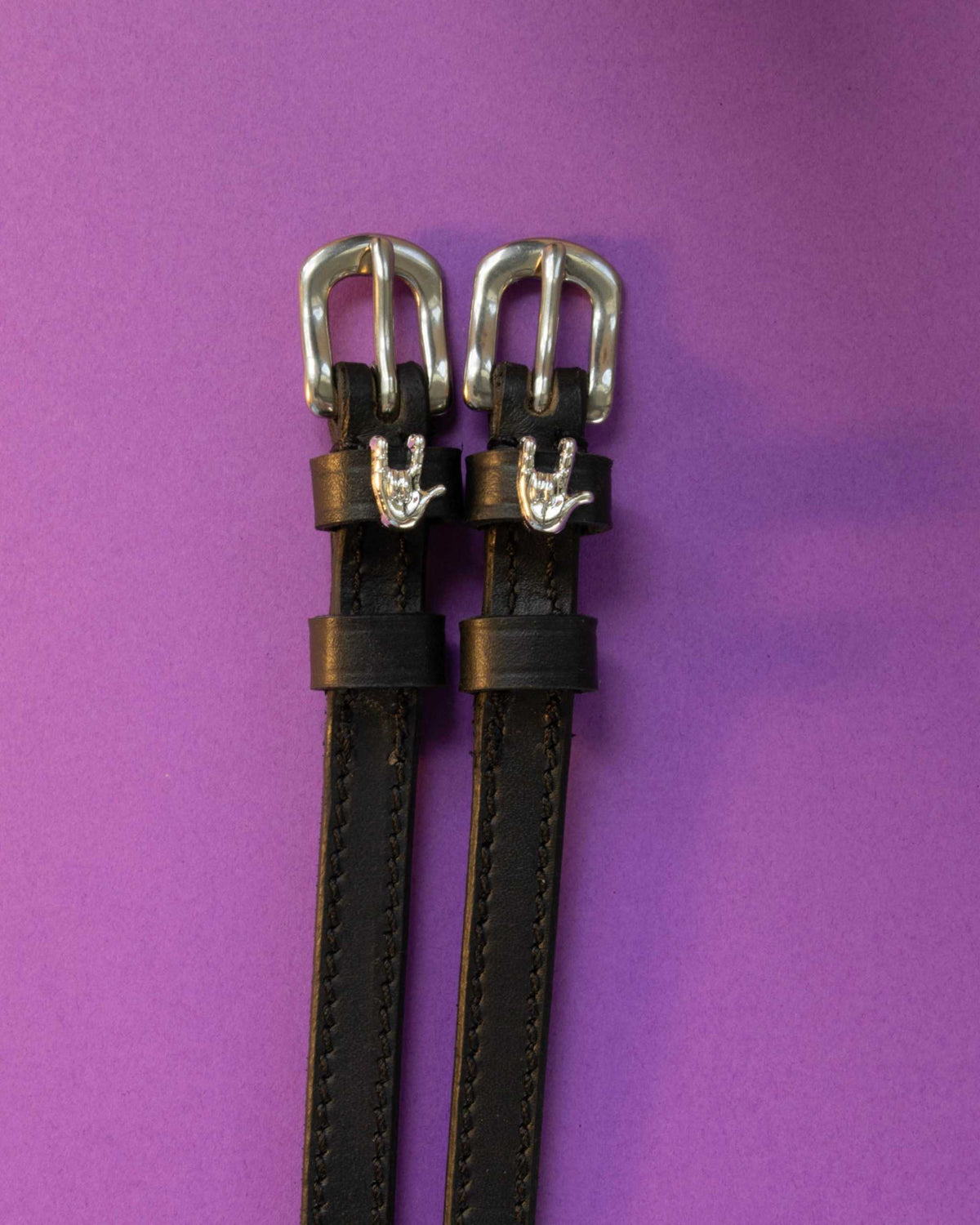 Rock On ManeJane spur straps with the signature Rock On charm, shown on a purple background