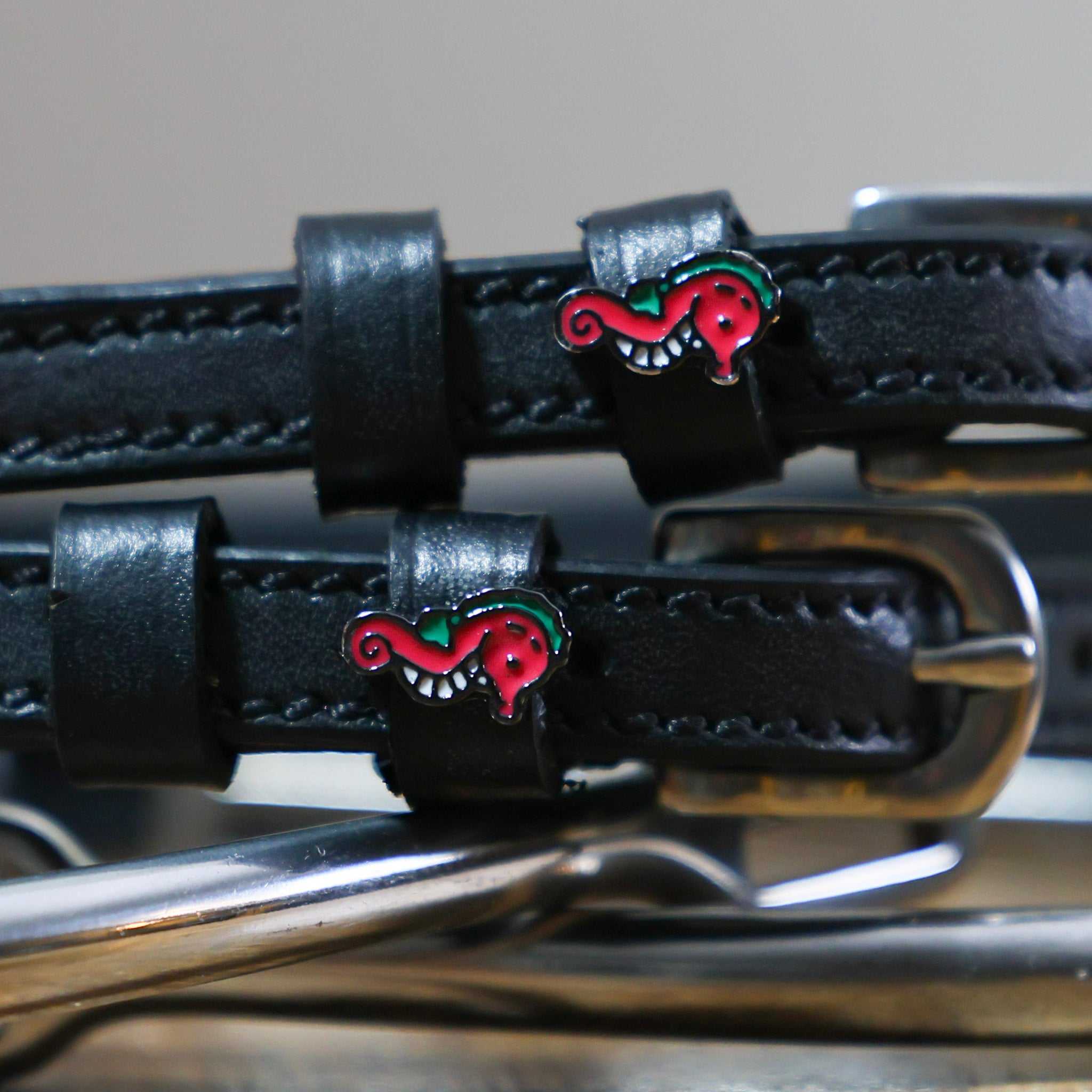 Black leather Spur Straps with stainless steel buckles and red seahorse charm