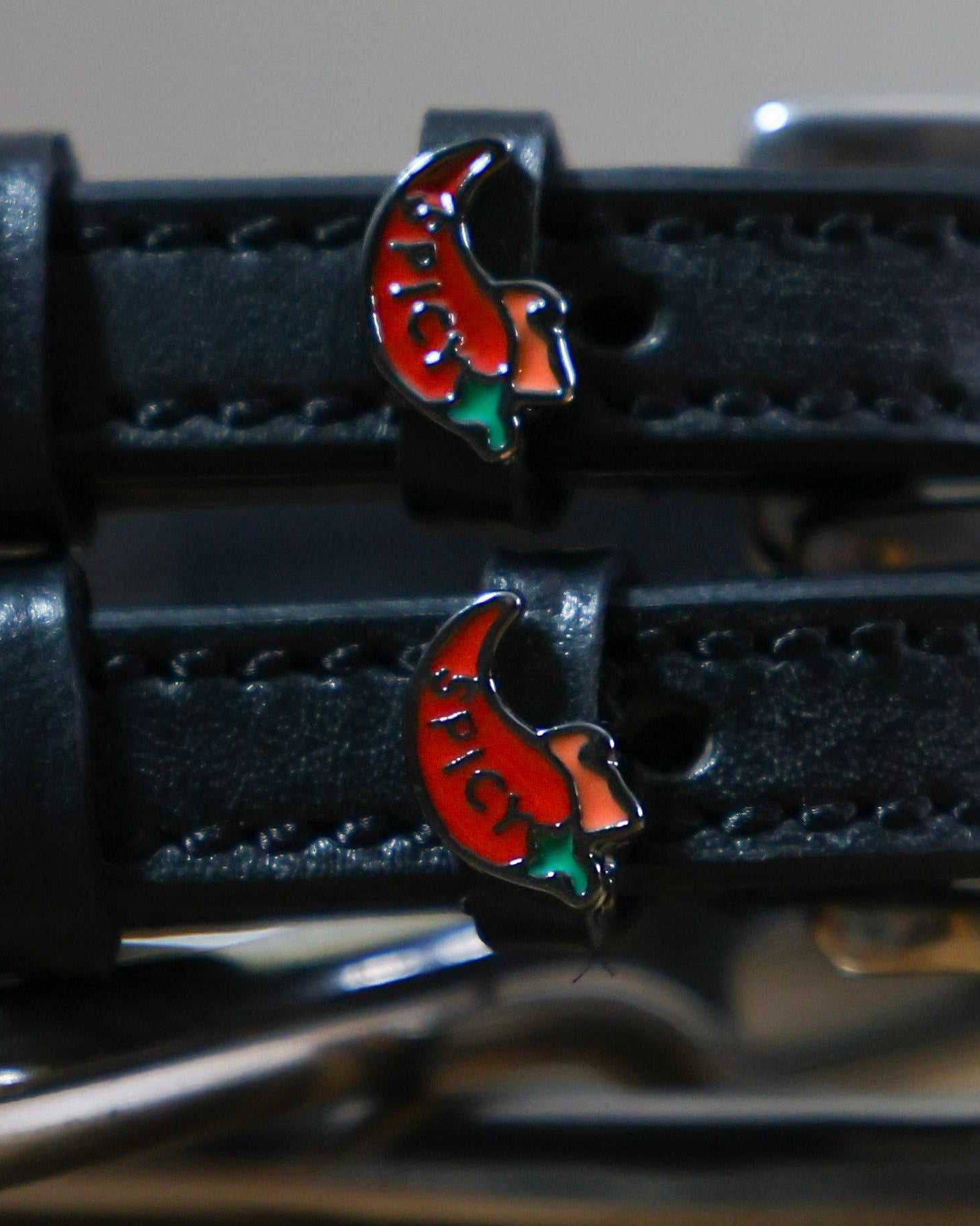 Black leather spur straps with red chili pepper charm and stainless steel buckle