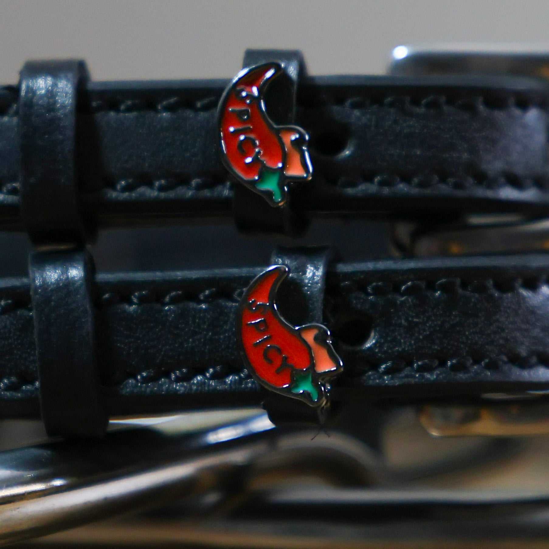 Black leather spur straps with red chili pepper charm and stainless steel buckle