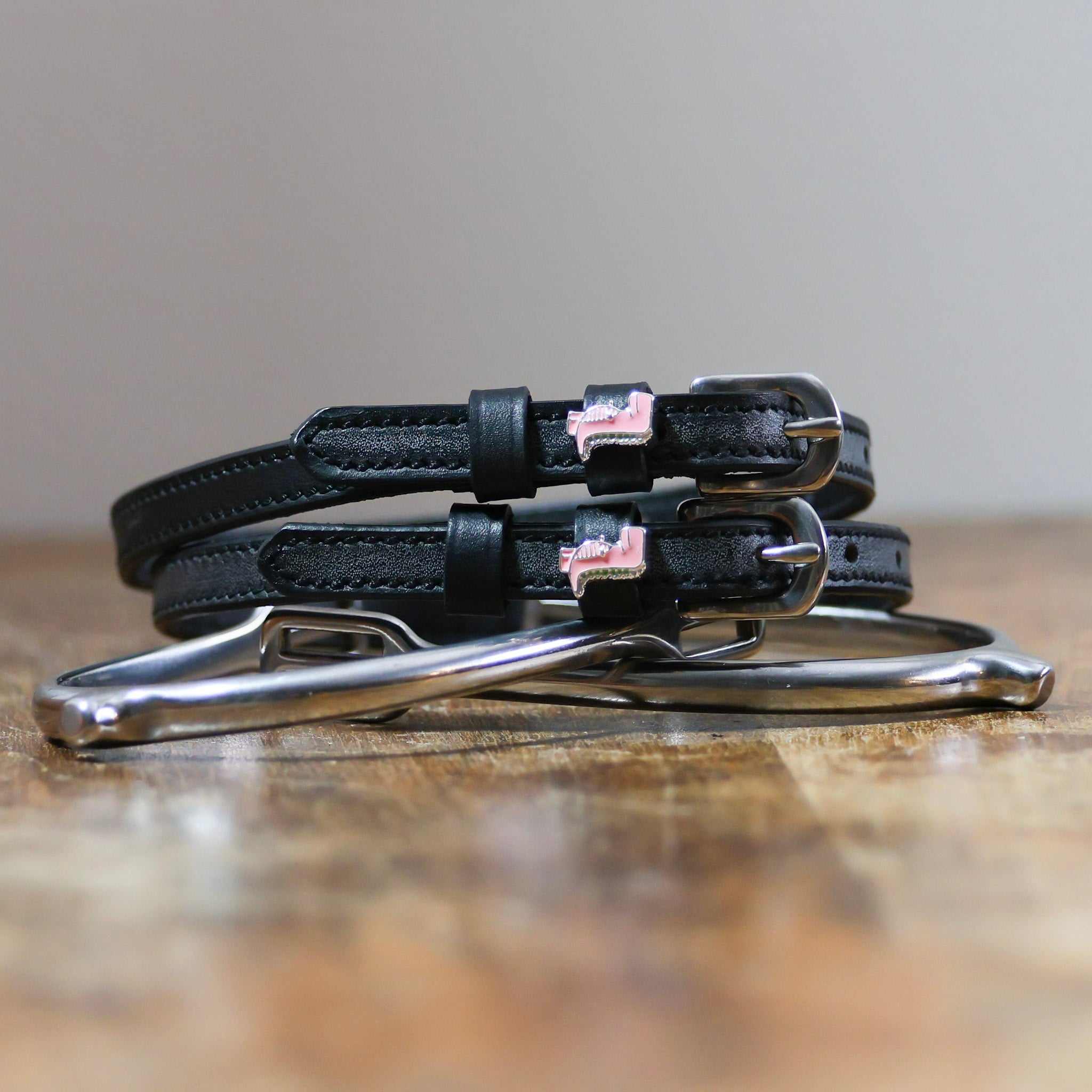 ManeJane Pink Dinosaur Spur Straps Spur Straps — black leather, non-stretch, hero image for English riders.