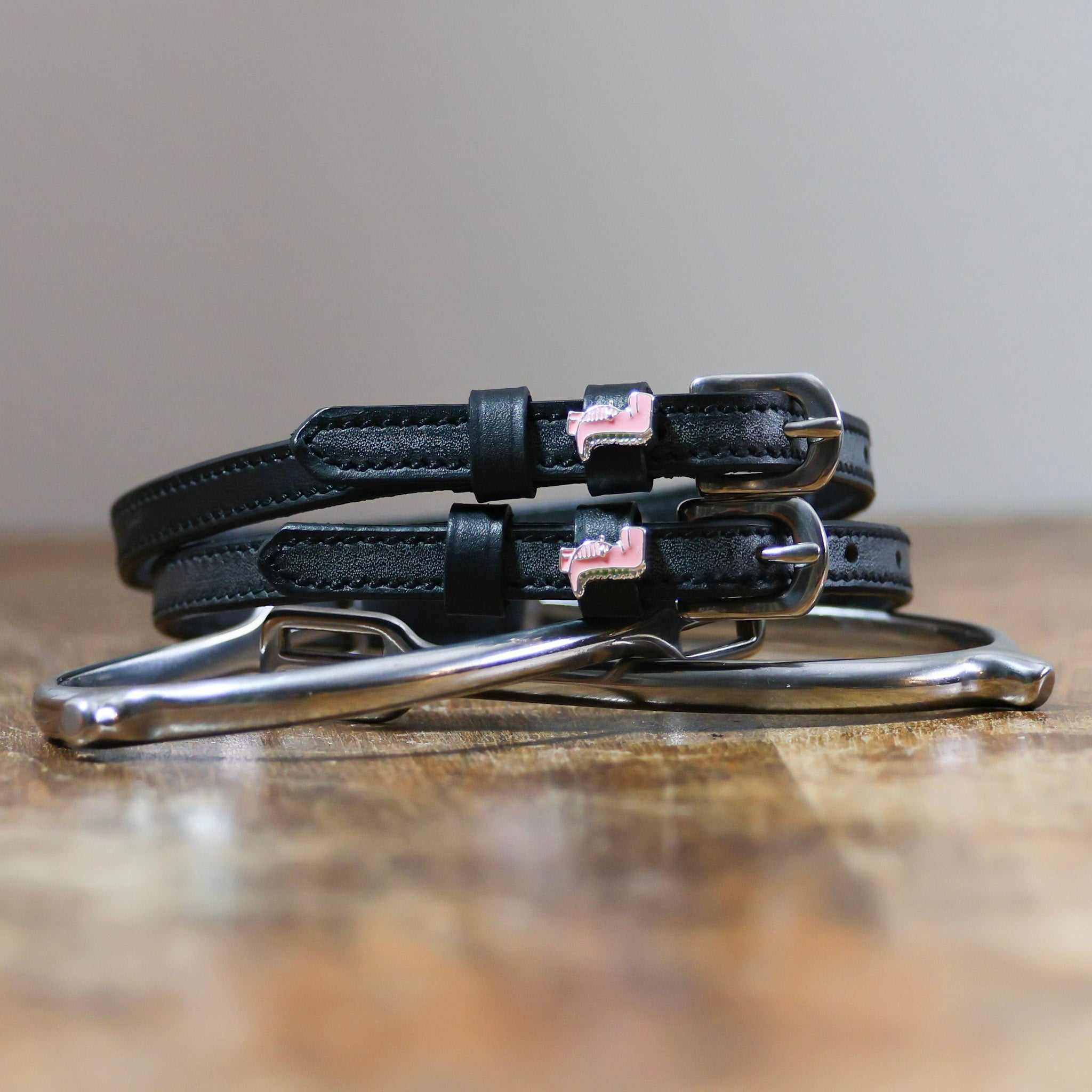 ManeJane Pink Dinosaur Spur Straps Spur Straps — black leather, non-stretch, hero image for English riders.