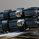Close-up of black leather Silver Apple Spur Straps with shiny silver apple charms and stainless steel buckles.