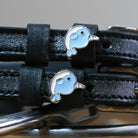 Black leather Narwhal Spur Straps with blue narwhal charm and stainless steel buckle close-up