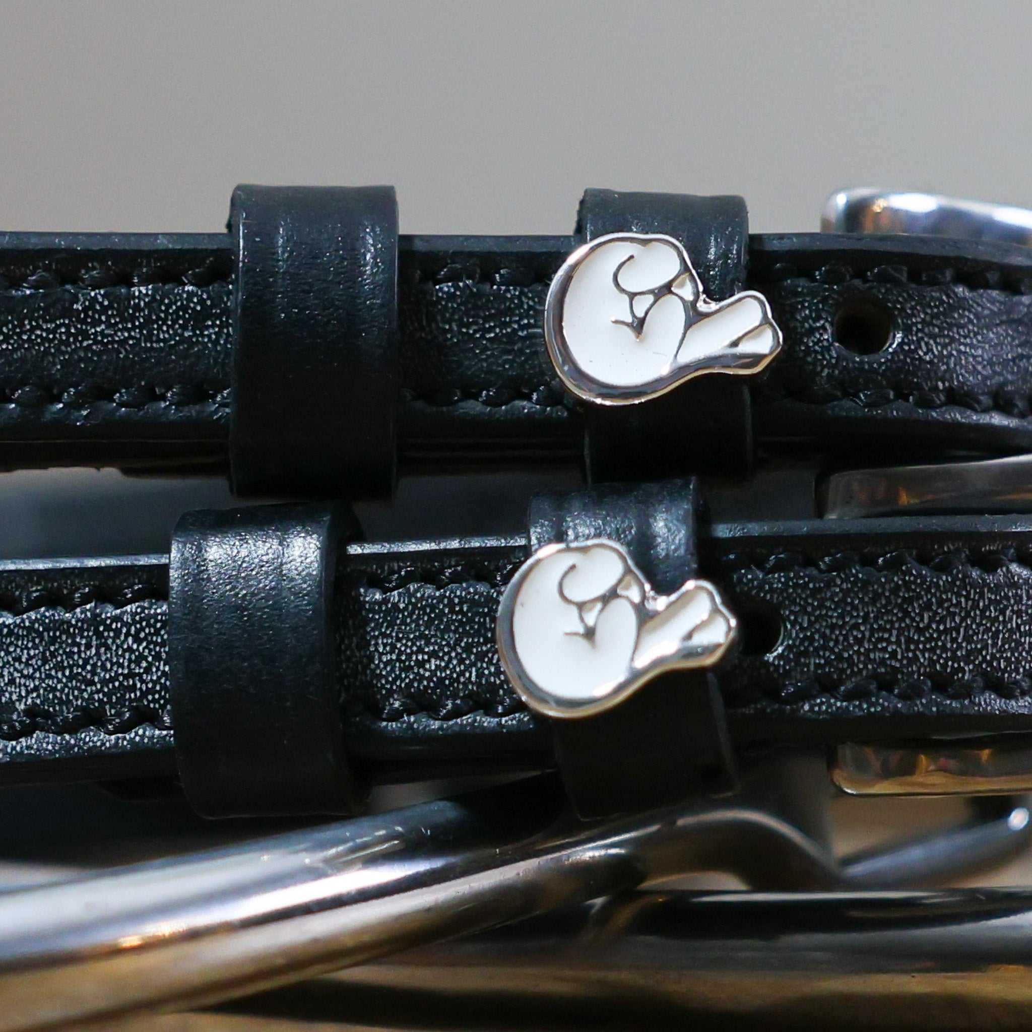 Black leather Fingers Crossed Spur Straps with stainless steel buckle and custom charm close-up