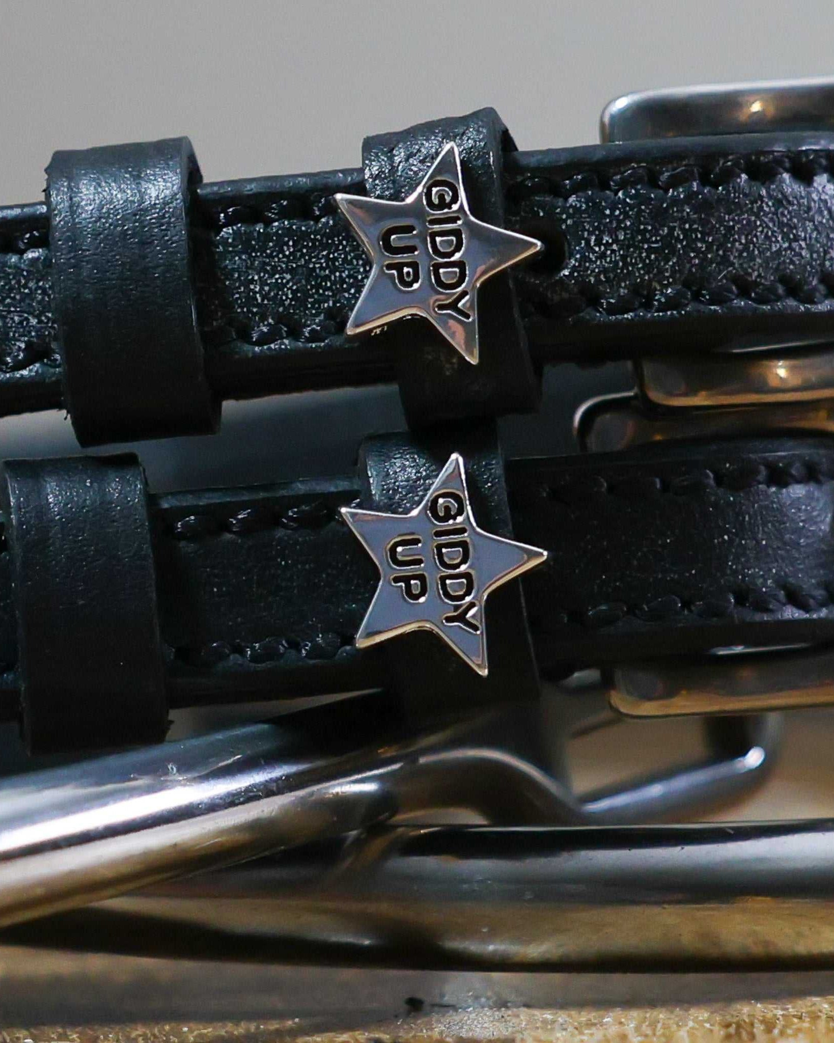 Giddy Up Spur Straps made of black leather with stainless steel buckles and star-shaped custom charms