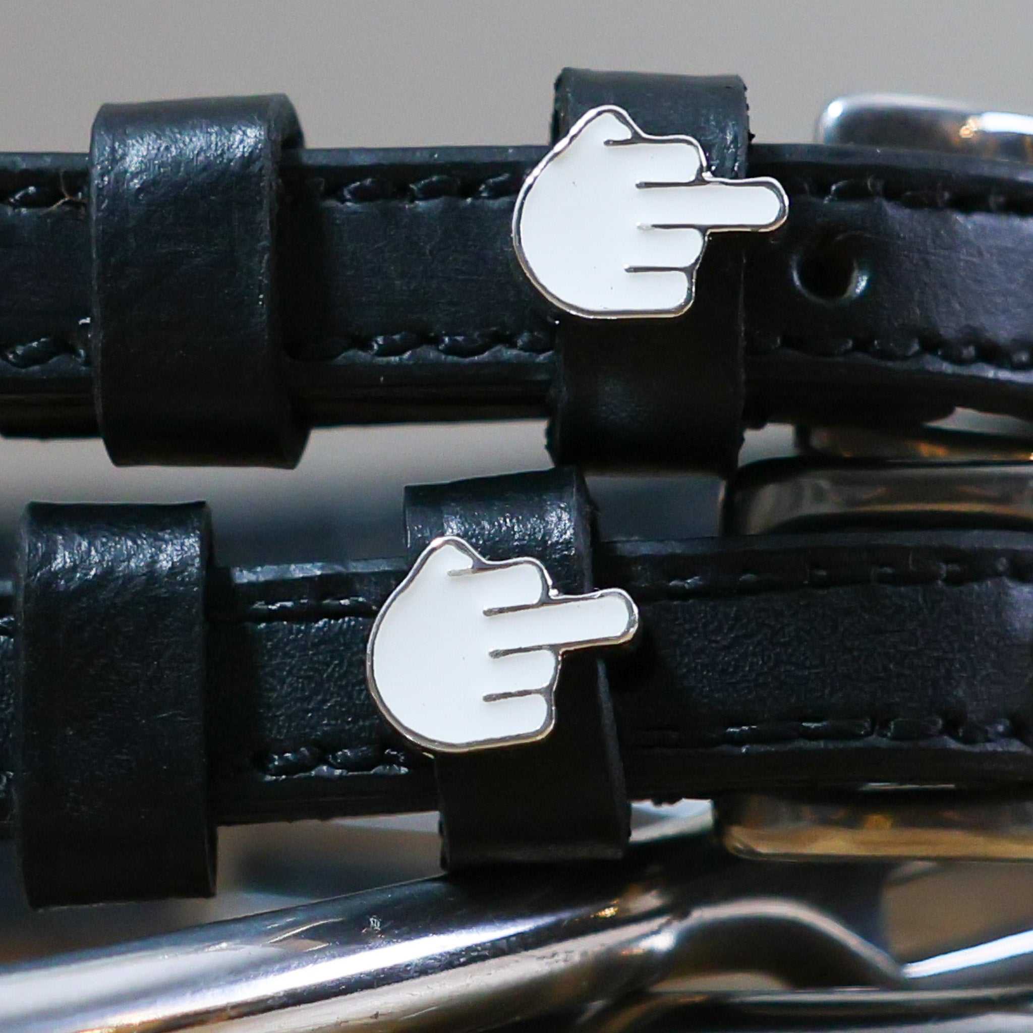 Black leather spur straps with custom metal hand gesture charms and stainless steel buckles
