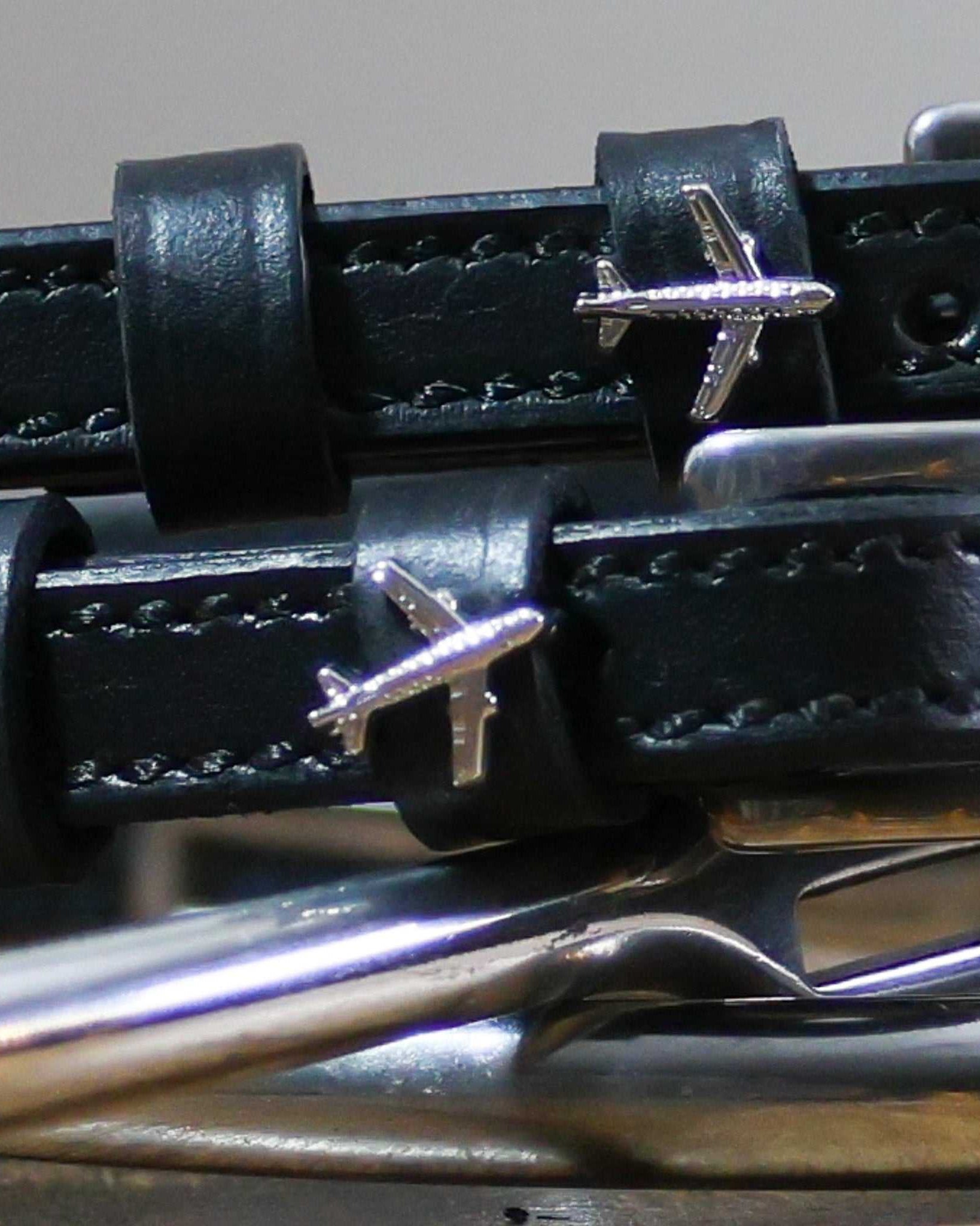Close-up of black leather Plane Spur Straps with stainless steel buckle and airplane charm