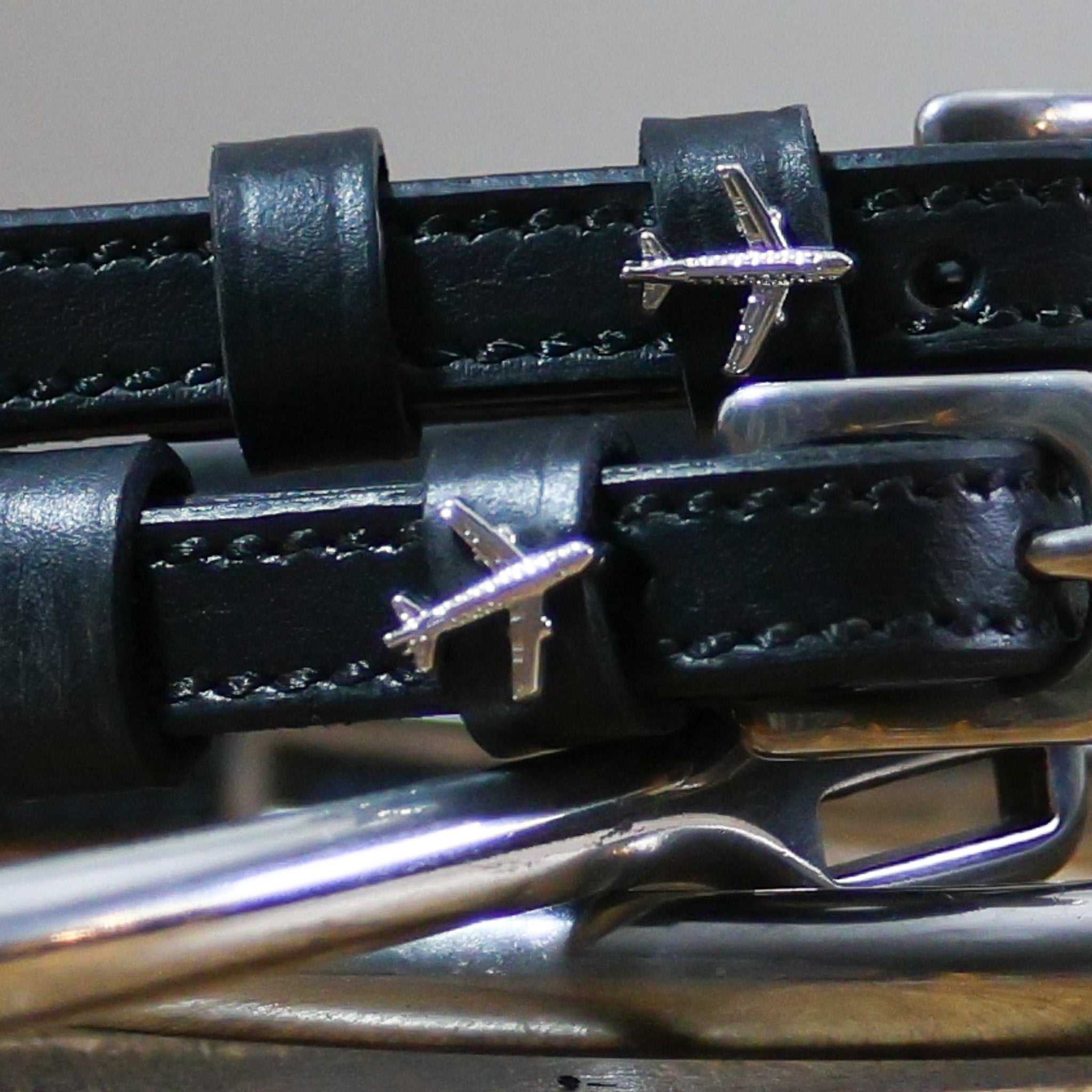 Close-up of black leather Plane Spur Straps with stainless steel buckle and airplane charm