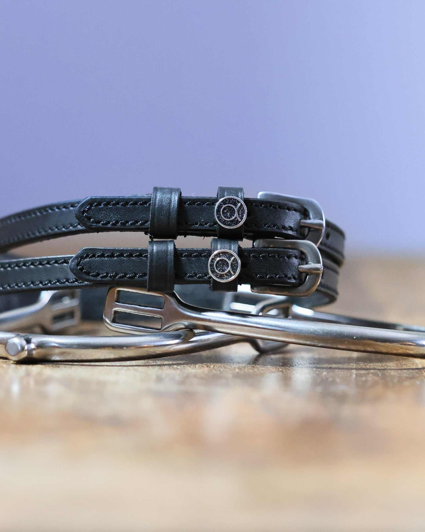 Black leather Taurus Spur Straps with stainless steel buckles and custom charms on metal spurs