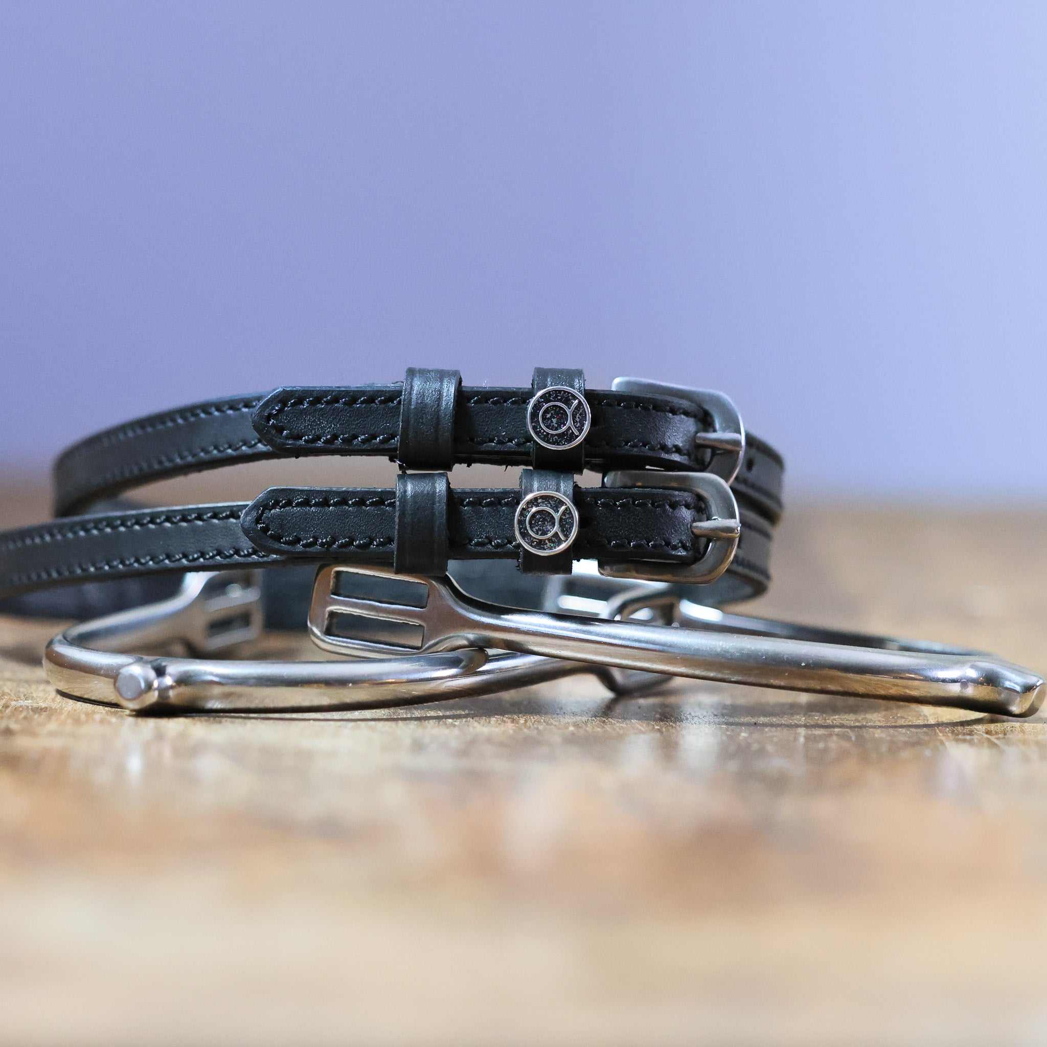 Black leather Taurus Spur Straps with stainless steel buckles and custom charms on metal spurs
