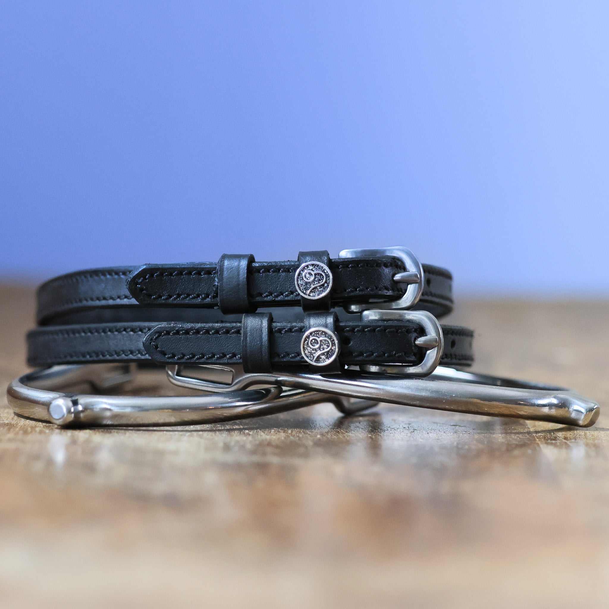 Black leather Leo Spur Straps with stainless steel buckles, custom charms, and durable non-stretch interior, 18 inches long