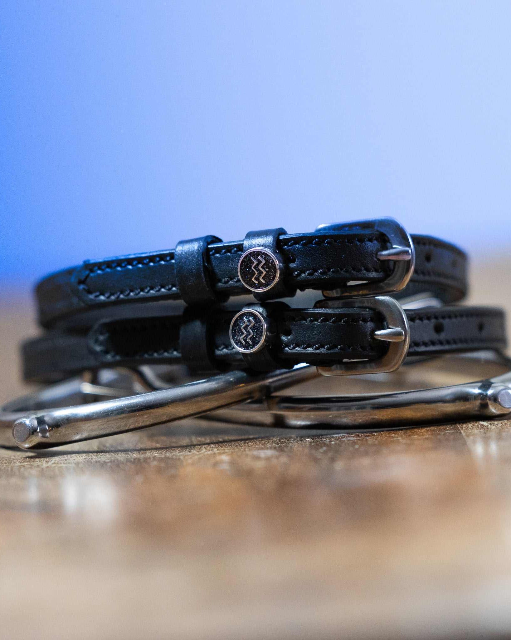 Black leather Aquarius Spur Straps with stainless steel buckles and custom ManeJane charms