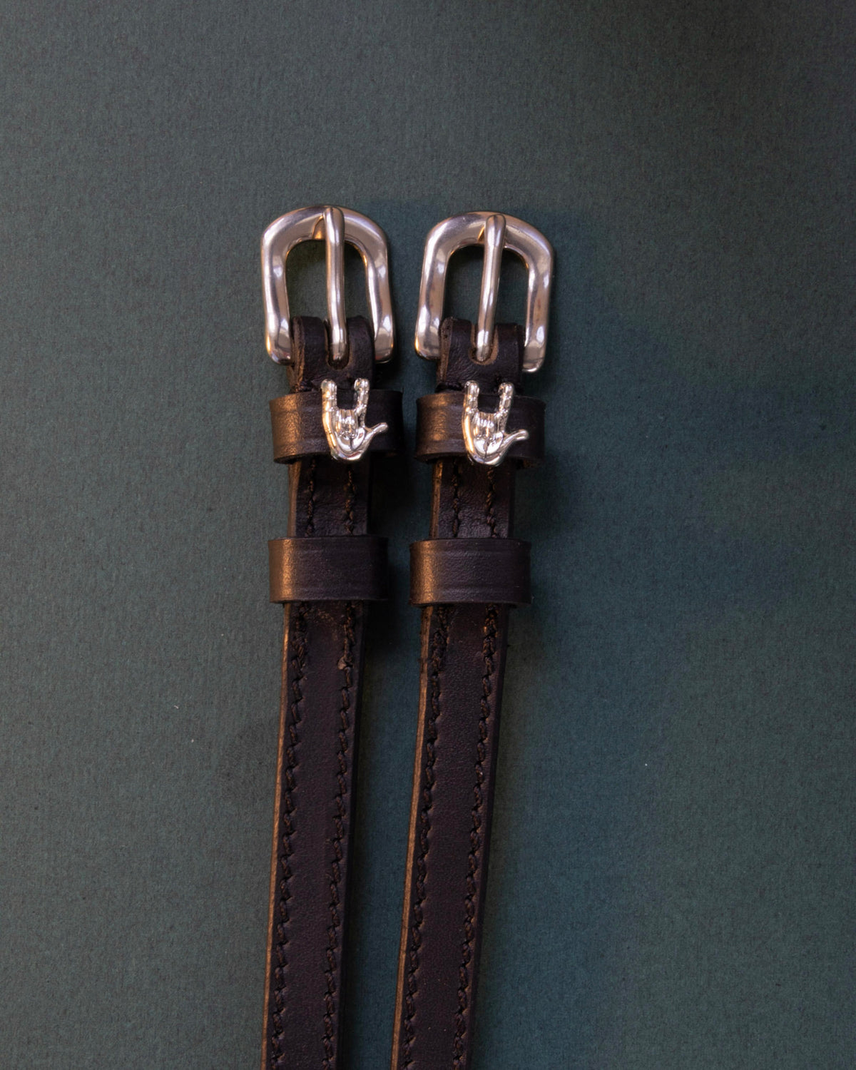 Rock On ManeJane spur straps with the signature Rock On charm, shown on a charcoal background