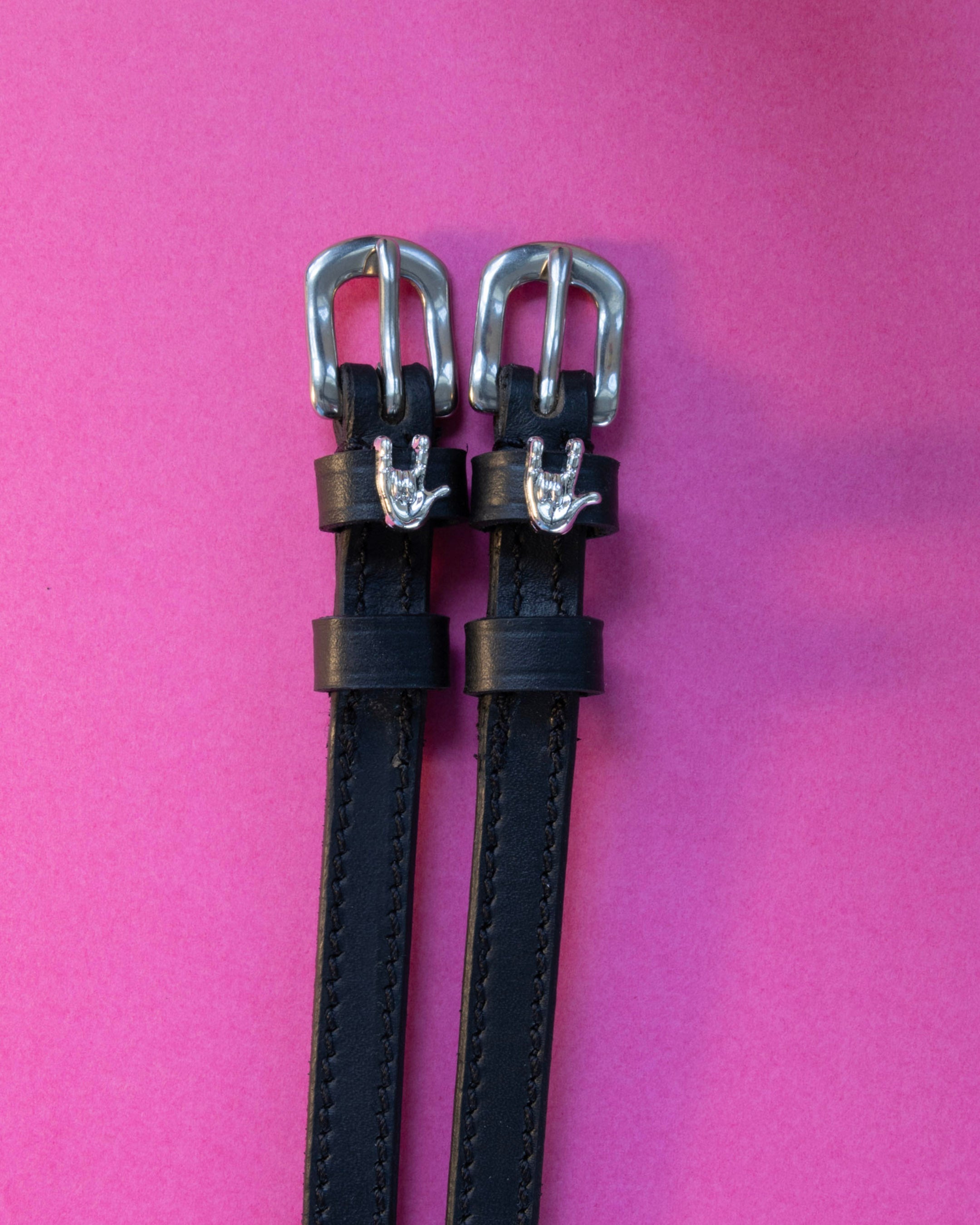 Rock On ManeJane spur straps with the signature Rock On charm, shown on a magenta background