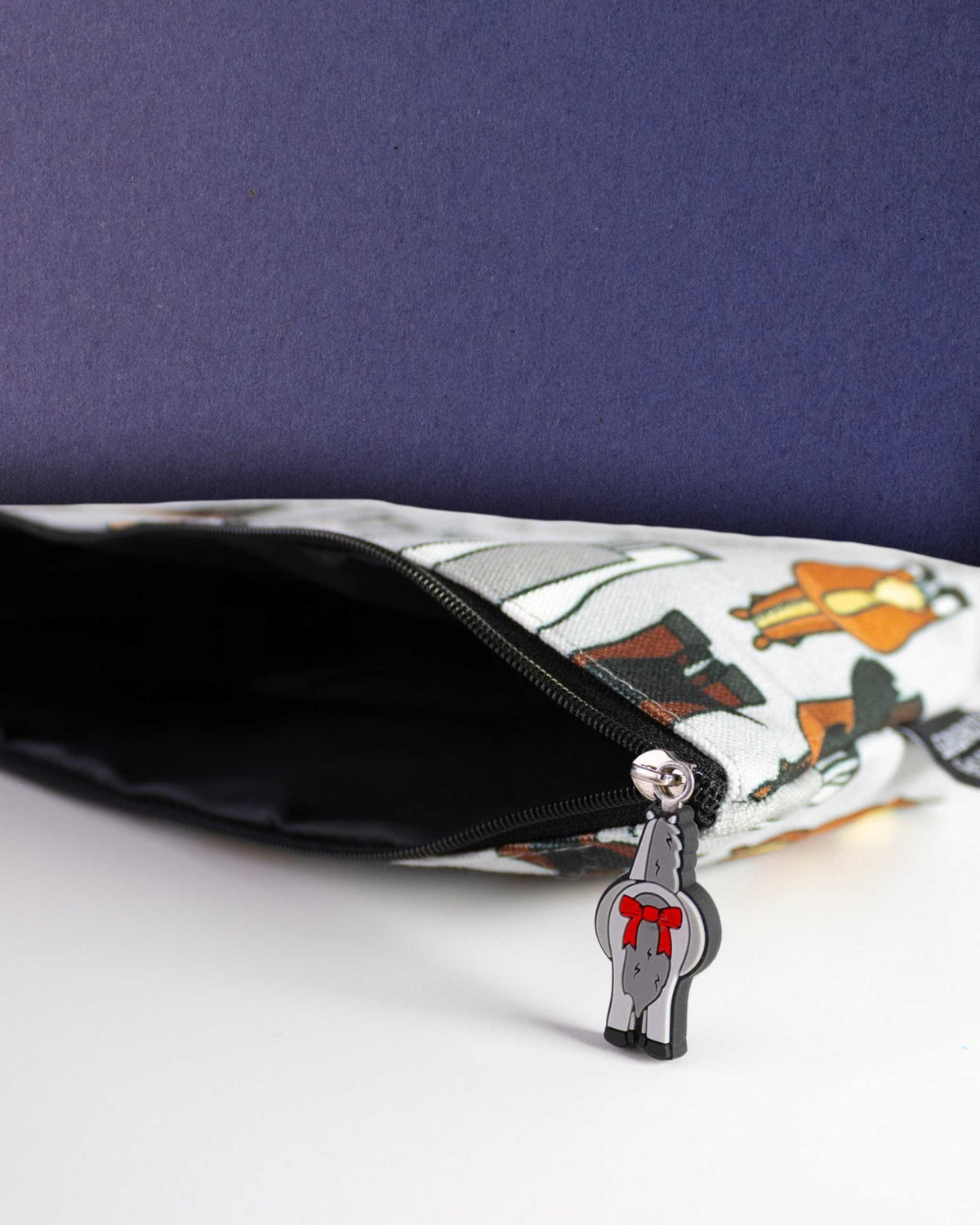 Butts zip pouch unzipped to show the black interior lining, bad pony charm on the zip pull