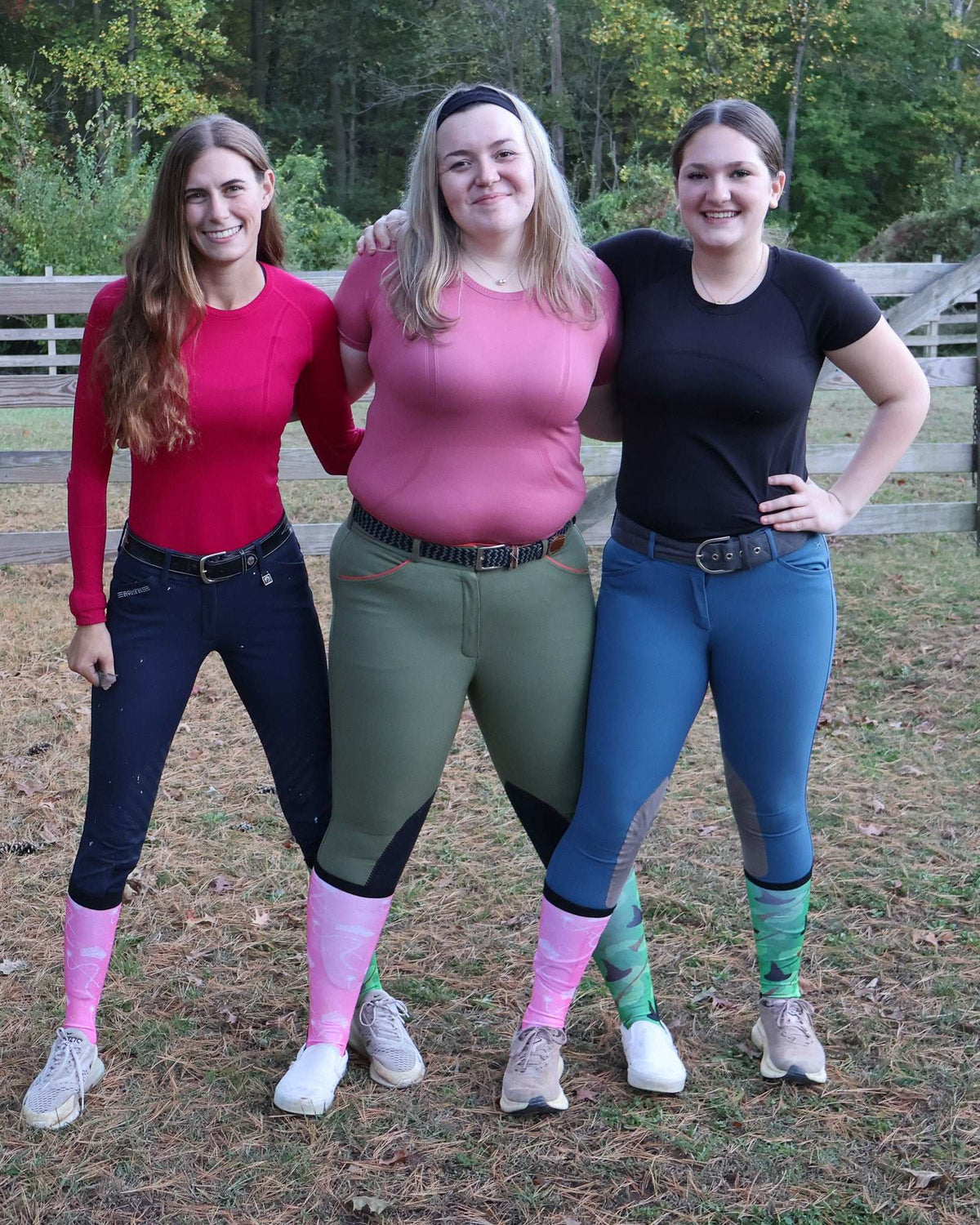Three women outdoors wearing colorful limited edition boot socks in pink and green patterns