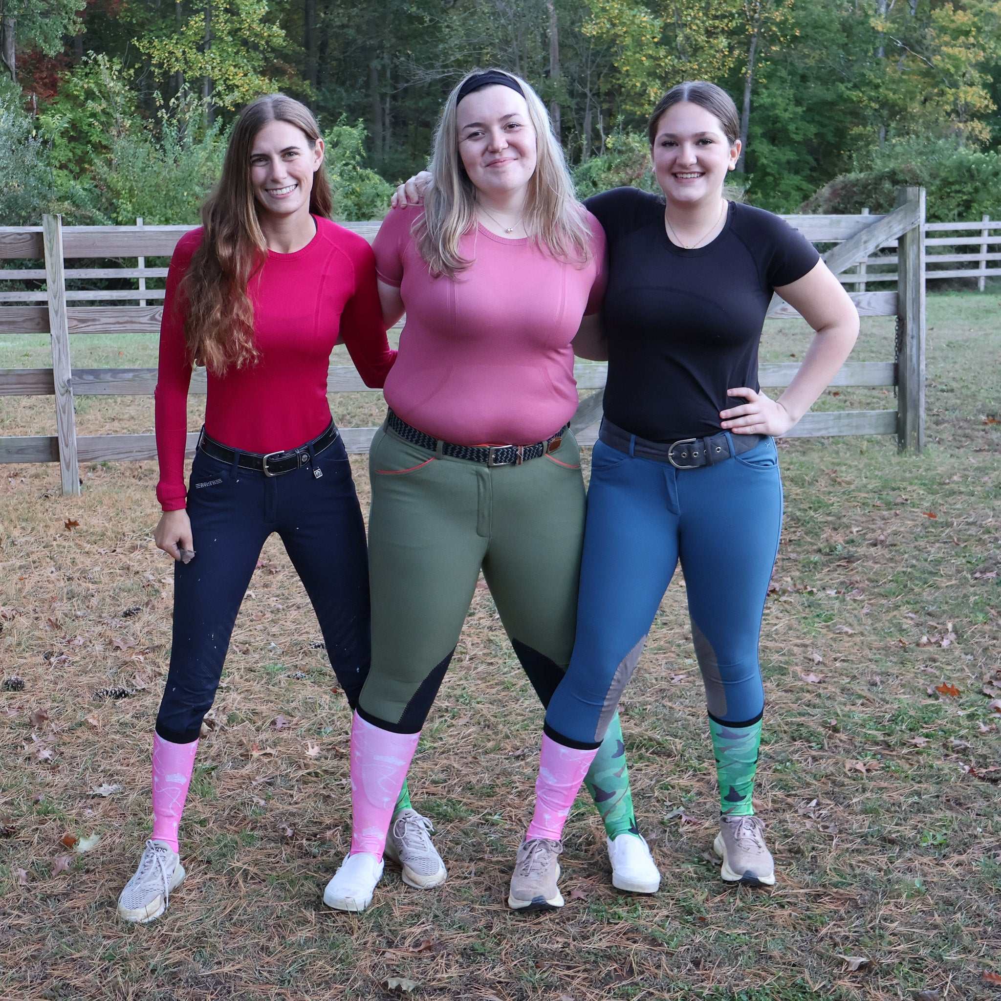 Three women outdoors wearing colorful limited edition boot socks in pink and green patterns