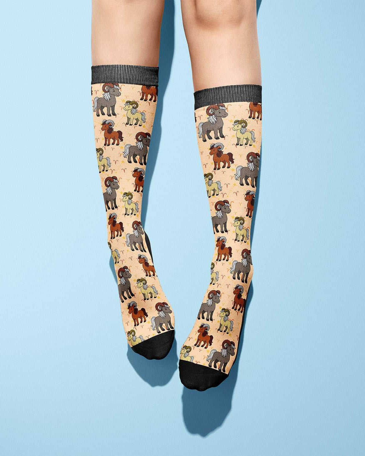 Aries zodiac themed boot socks in beige with black toes and ram illustrations, made in the USA