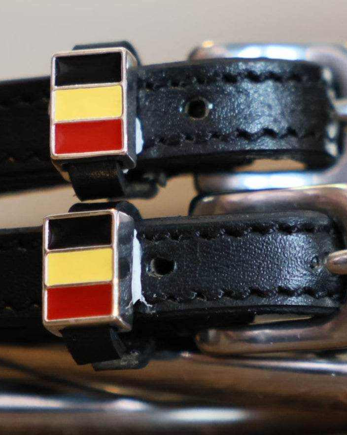 Close-up of black-yellow-red Belgian flag charms on black leather spur straps