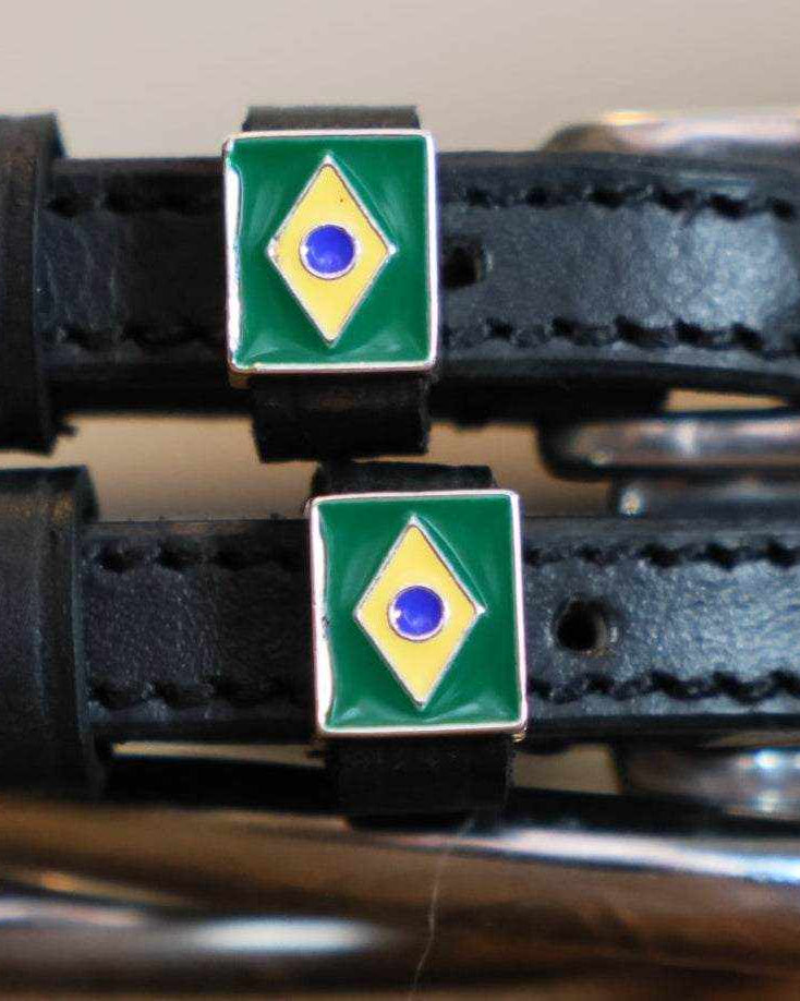 Close-up of Brazilian flag charms on black leather spur strap keepers by a stirrup