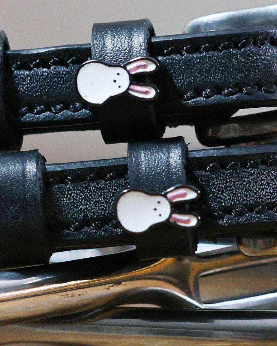 Close-up of white bunny face charms on black leather Bunny Hop spur straps, ManeJane