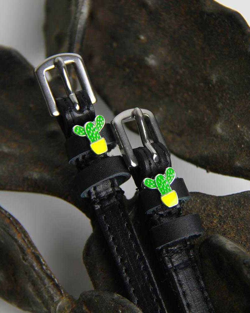 Green cactus charm ManeJane spur straps styled over dark dried seed pods