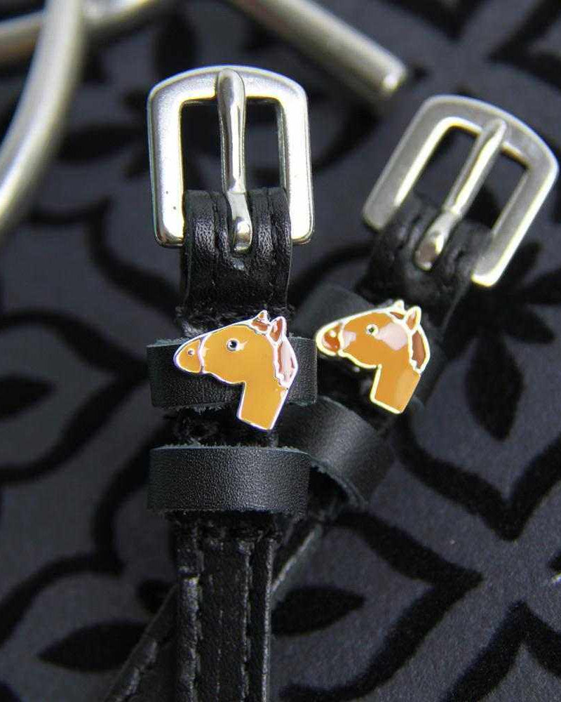Chestnut horse-head charms and silver buckles on black spur straps, black print