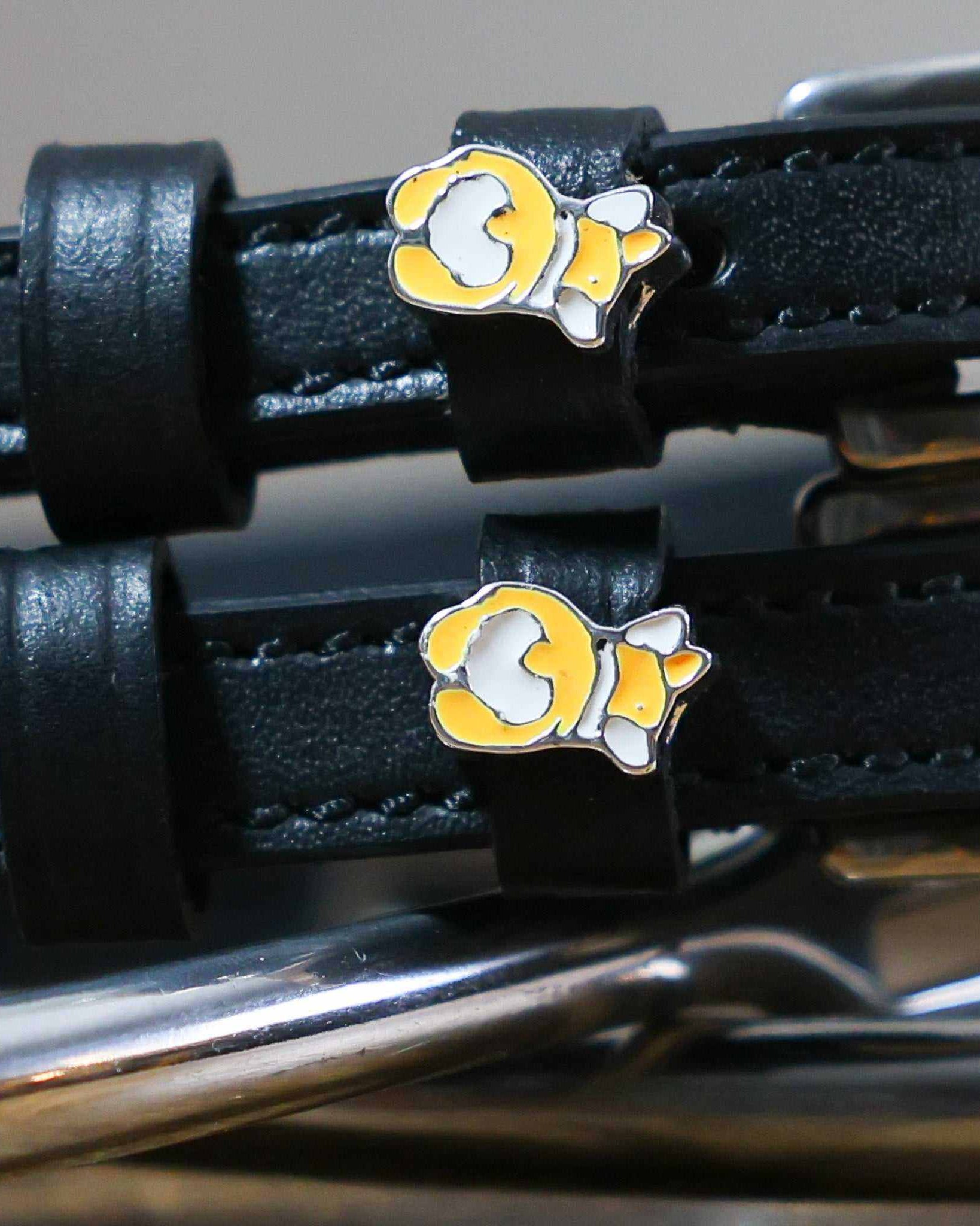 Close-up of a corgi butt charm on a black leather spur strap keeper