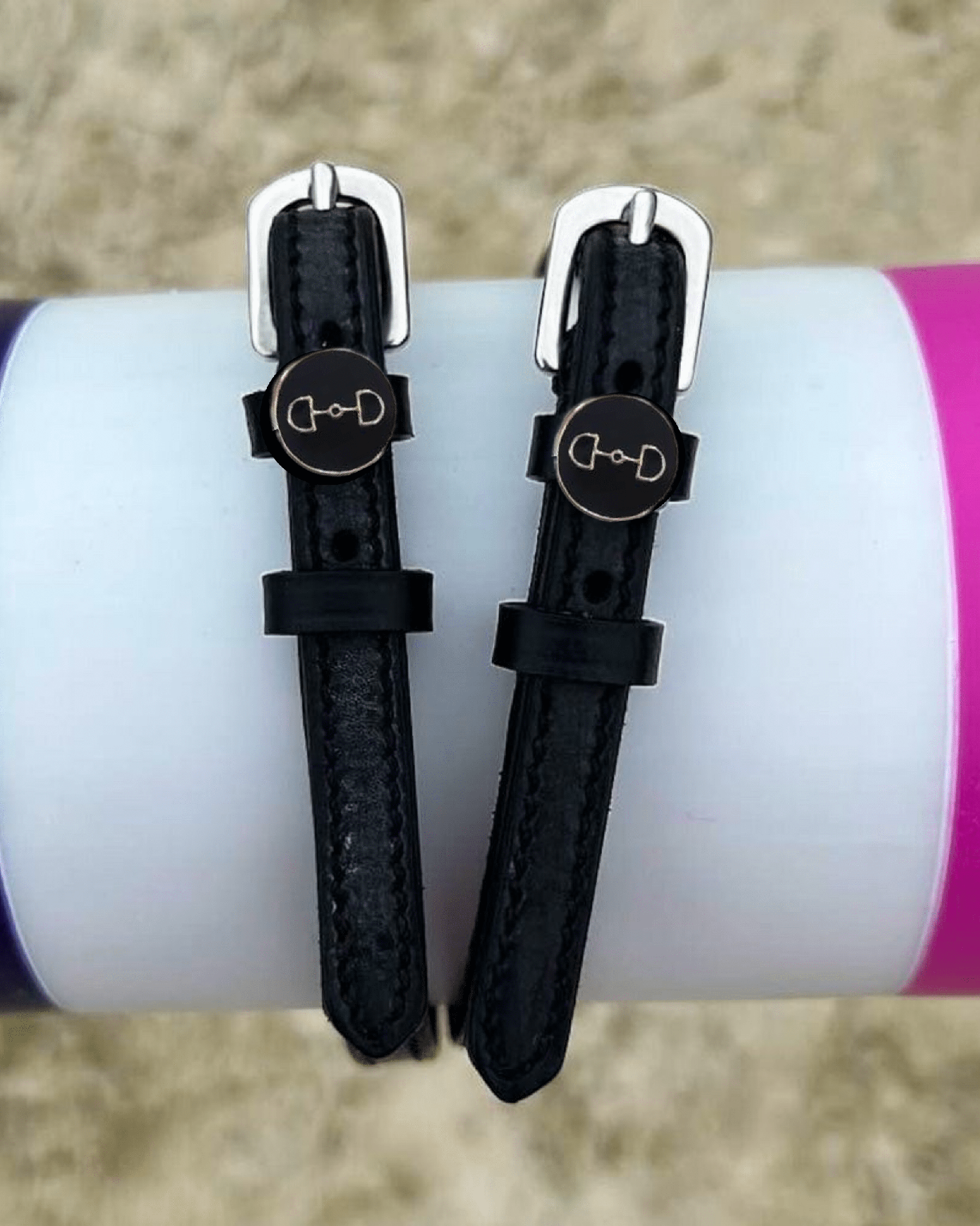 ManeJane D-ring spur straps wrapped around a white bottle outdoors