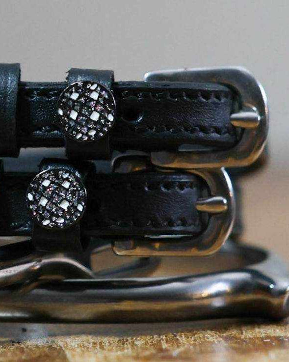 Close-up of crystal disco ball charms on black leather ManeJane spur strap keepers