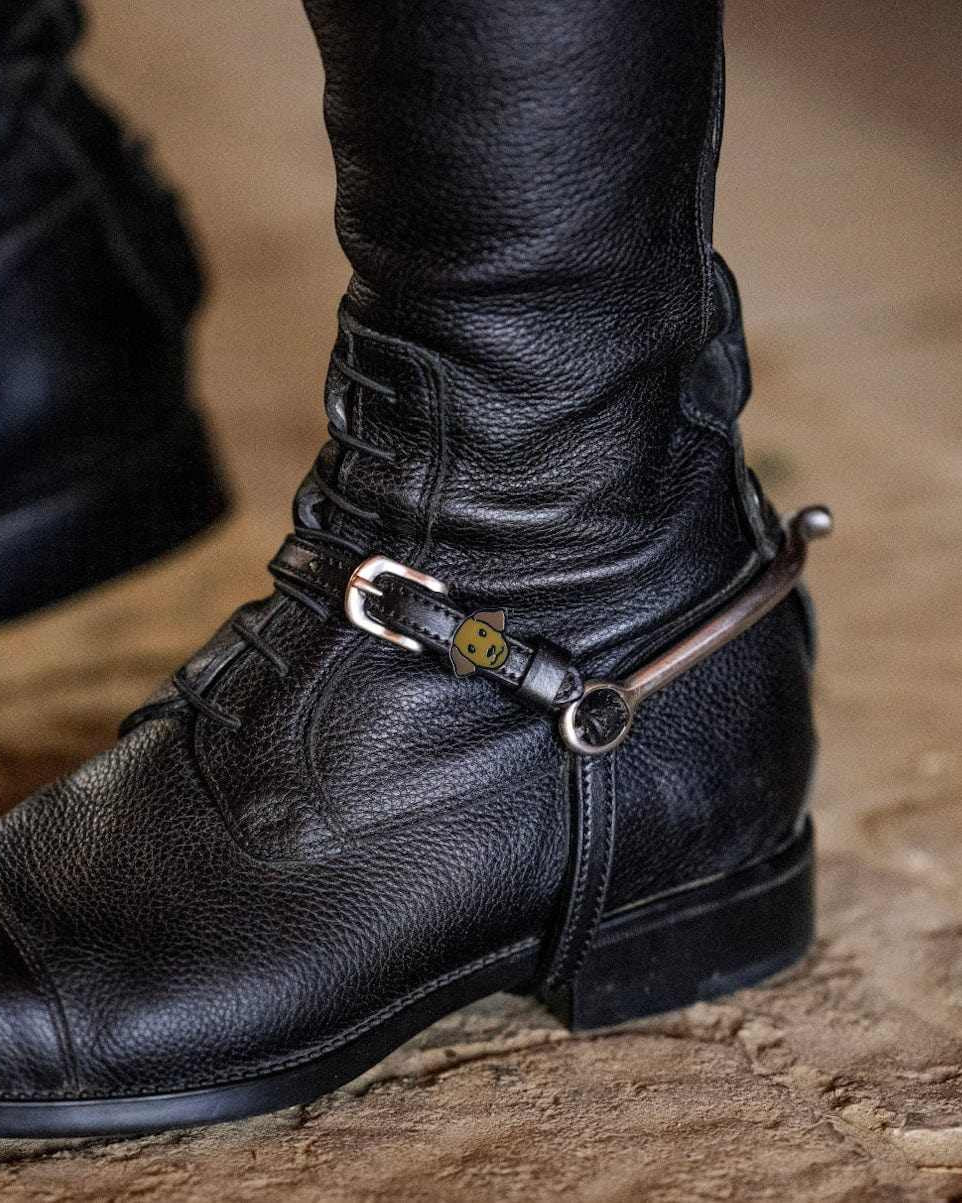 Labrador dog spur straps fastened on a rider's black English riding boot with spur