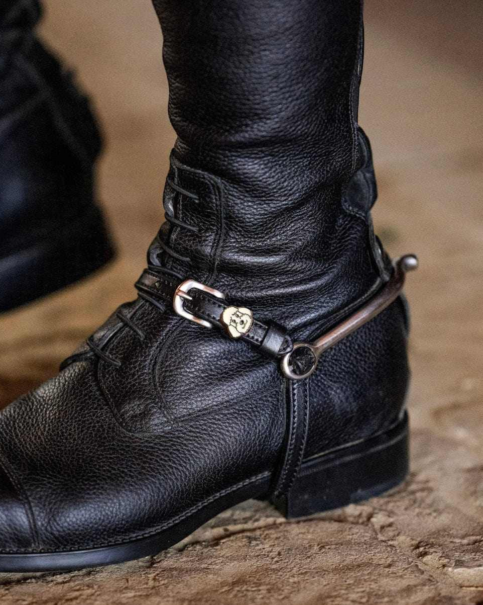 ManeJane poodle spur strap fastened on a rider's black English riding boot