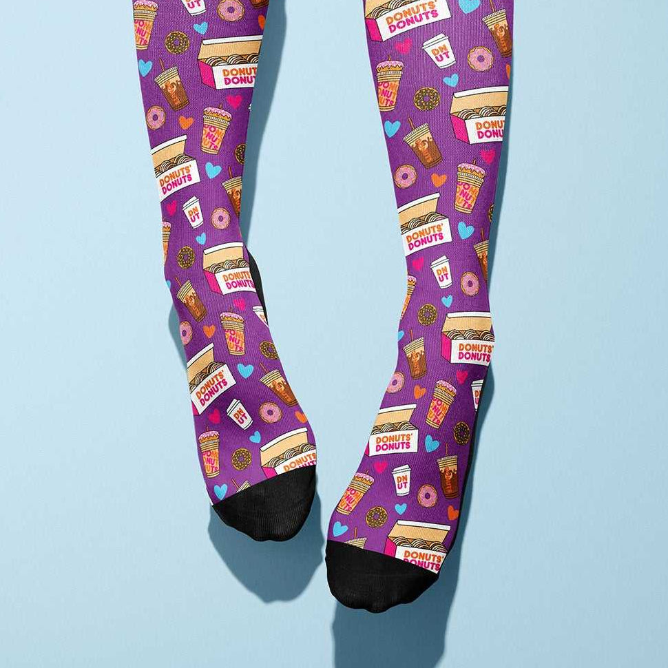 Pair of purple Donut Donutz themed socks with coffee and donut graphics on light blue background