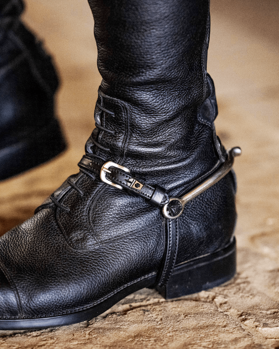 ManeJane spur strap and spur fastened on a rider's black English riding boot
