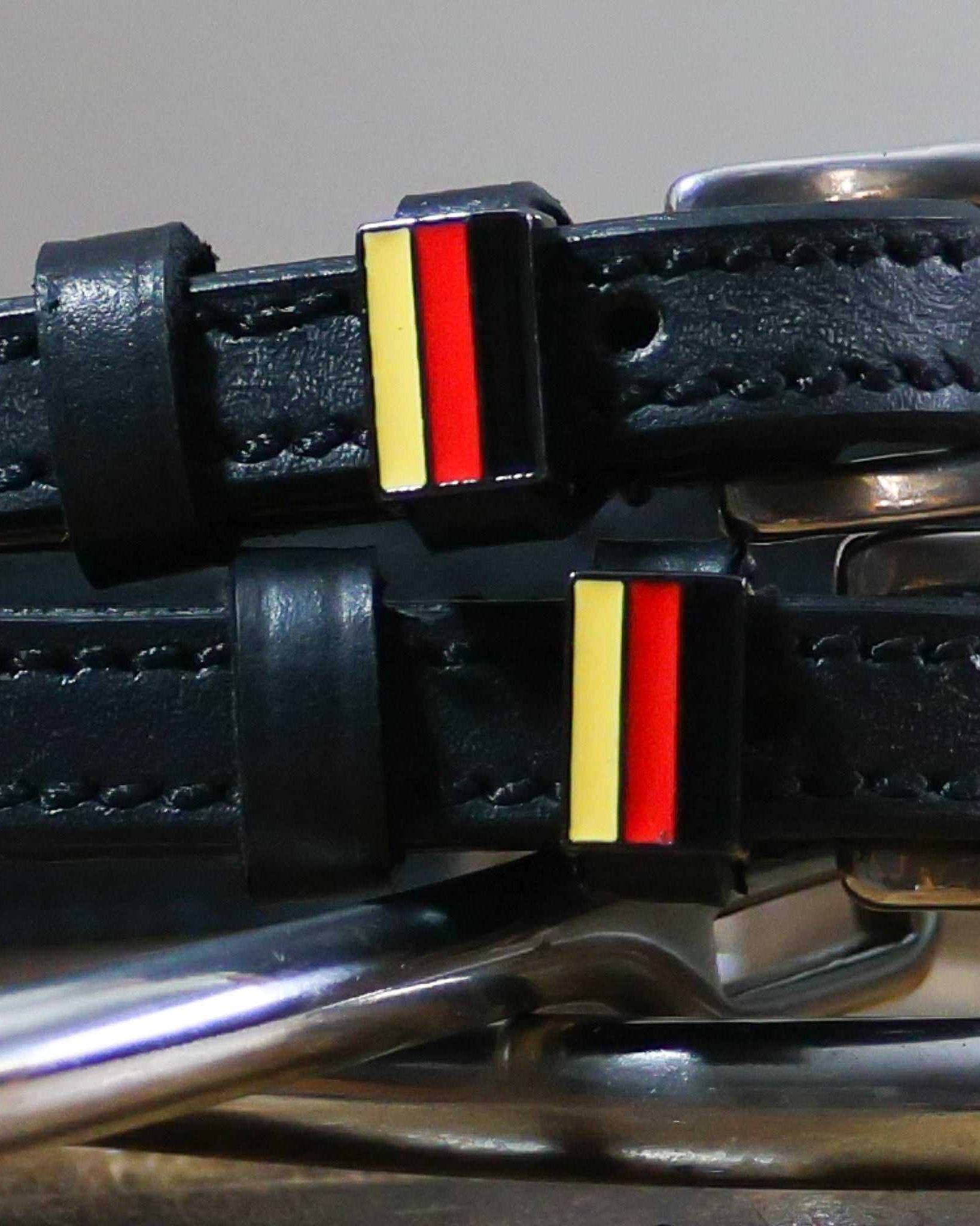 Close-up of black-red-gold German flag charms on black leather spur strap keepers