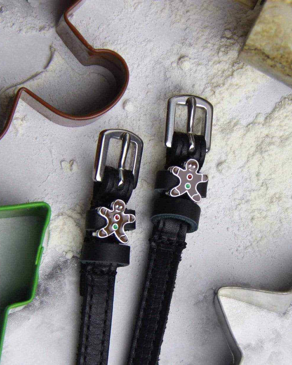 Gingerbread man spur straps on a floured board with festive cookie cutters