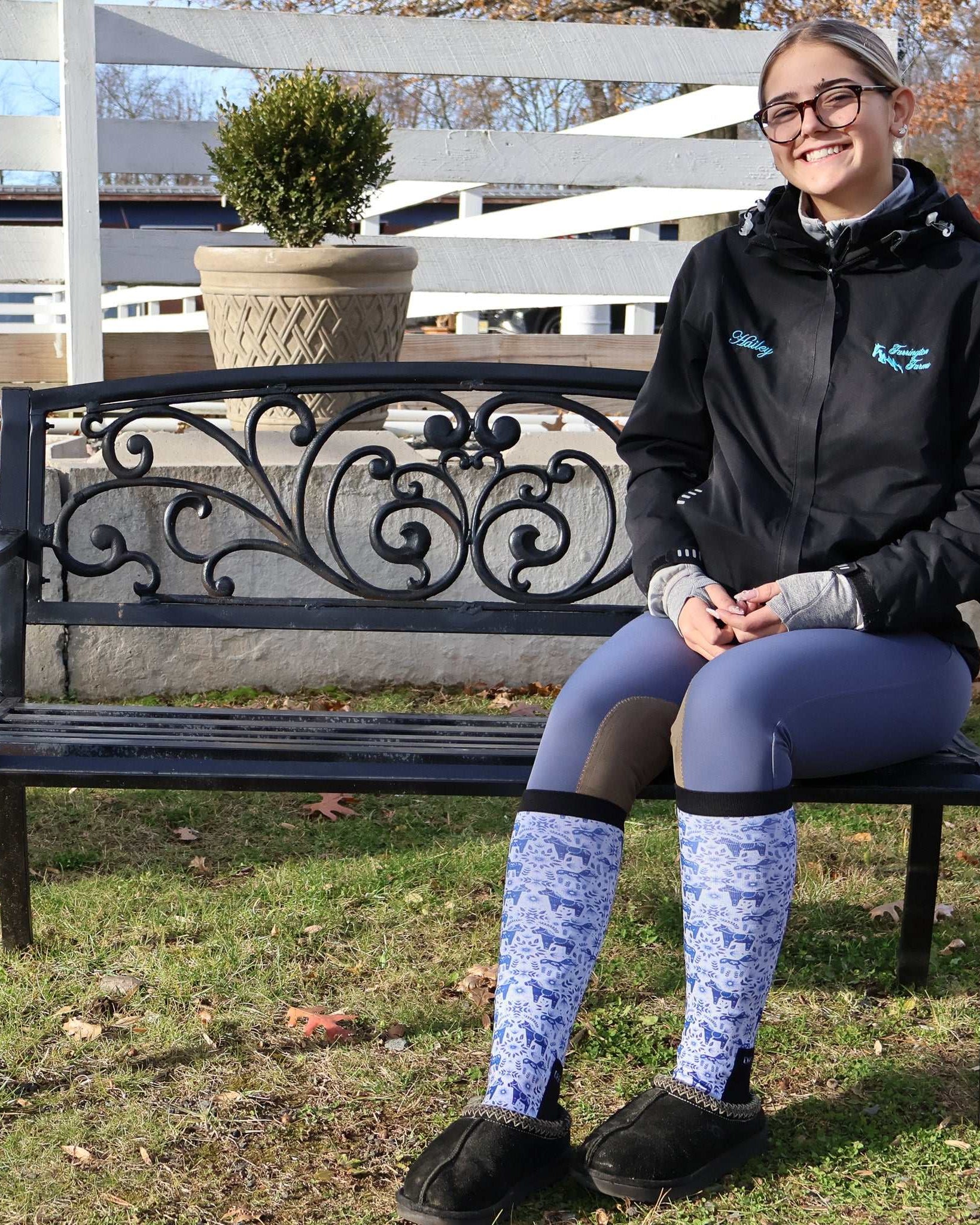 woman sitting on bench wearing Limited Edition Pony Island Dala Horses Socks with blue and white folk-art pony design