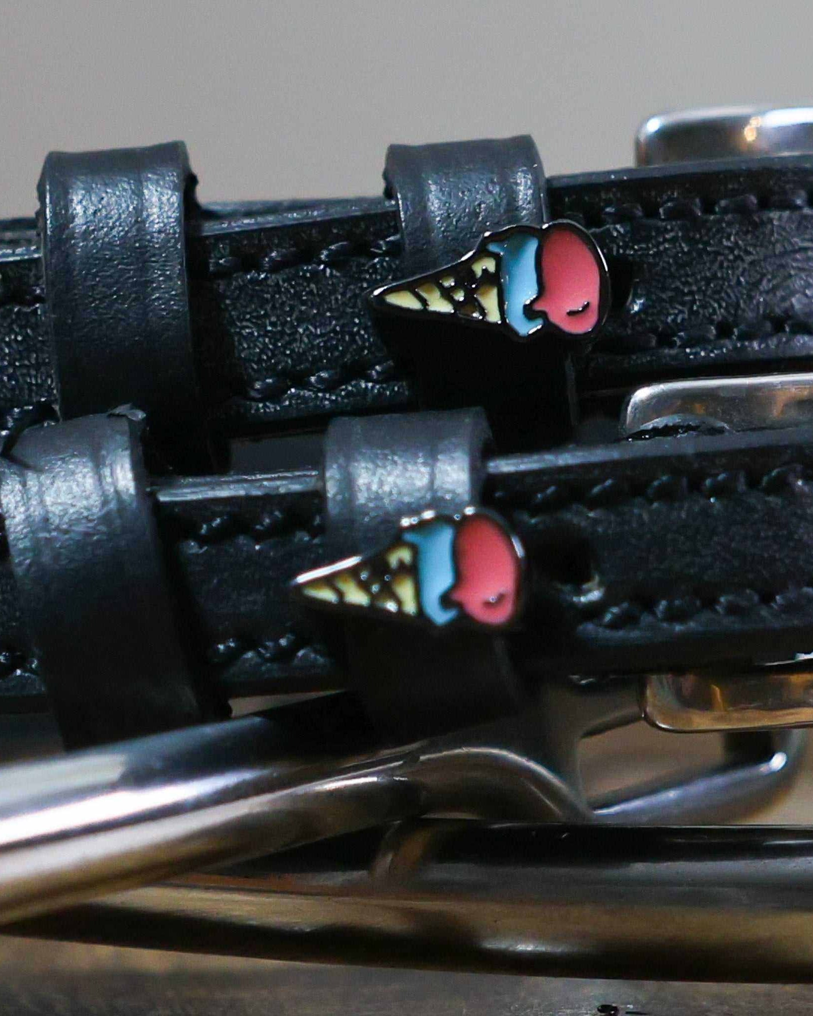 Close-up of ice cream cone charms on black leather ManeJane spur strap keepers