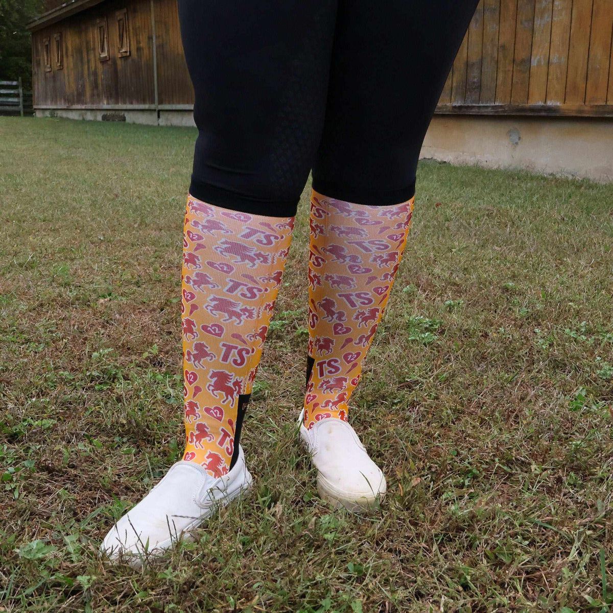 Limited edition Life of a Horse ShowGirl boot socks with colorful horse patterns, worn with black leggings and white shoes outdoors