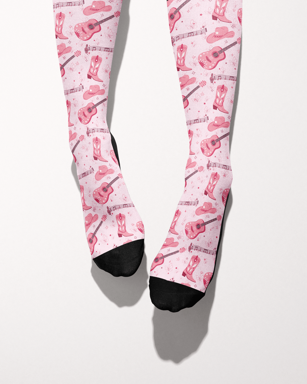 Dolly Forever socks shown on bare feet with black toes, pink cowgirl-themed print