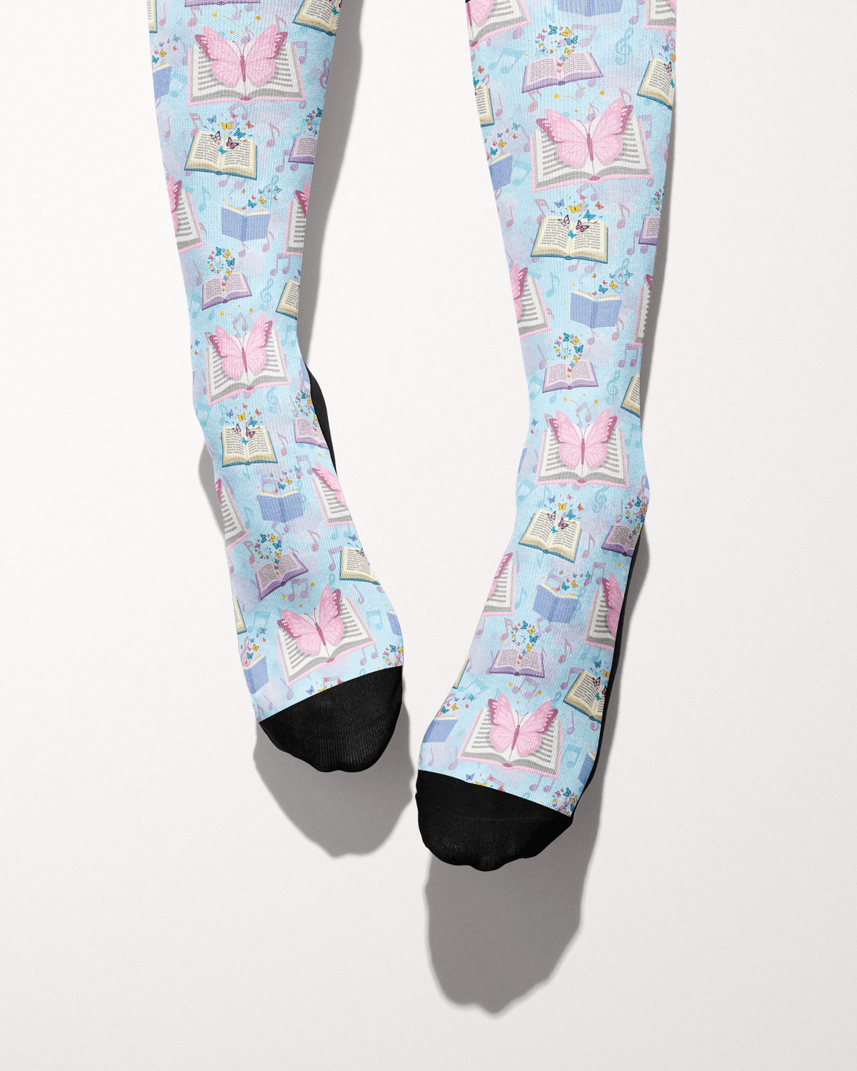 Reading 9-5 socks shown on bare feet, black toes against the books-and-butterflies print