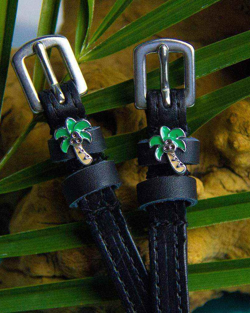 Palm tree spur straps styled among tropical palm fronds and driftwood