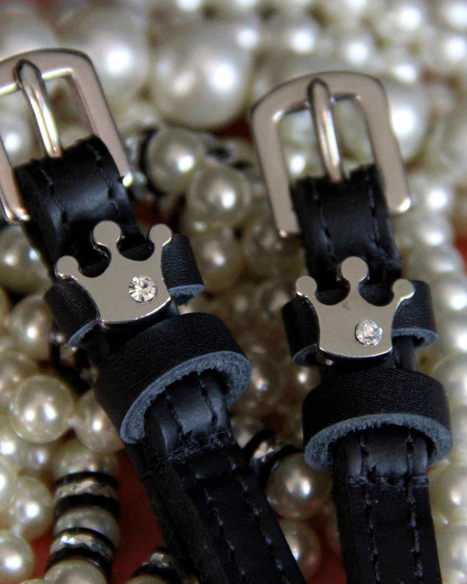Queenie crown spur strap buckle ends styled on a bed of pearls